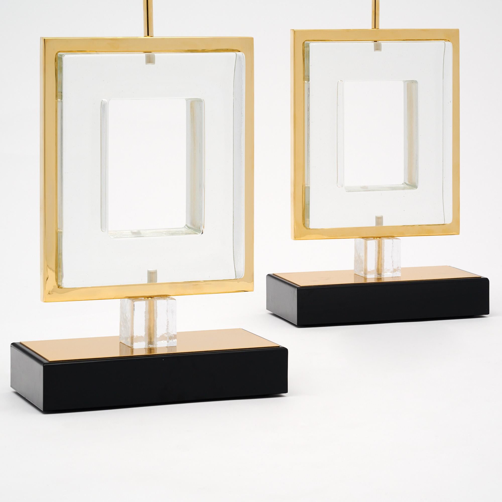 Coppia di lampade da tavolo provenienti dall'isola di Murano, fuori Venezia, Italia. Questa coppia ha una base in ottone e nero con una struttura in ottone che sostiene un quadrato in vetro trasparente soffiato a mano. Il design modernista mette in