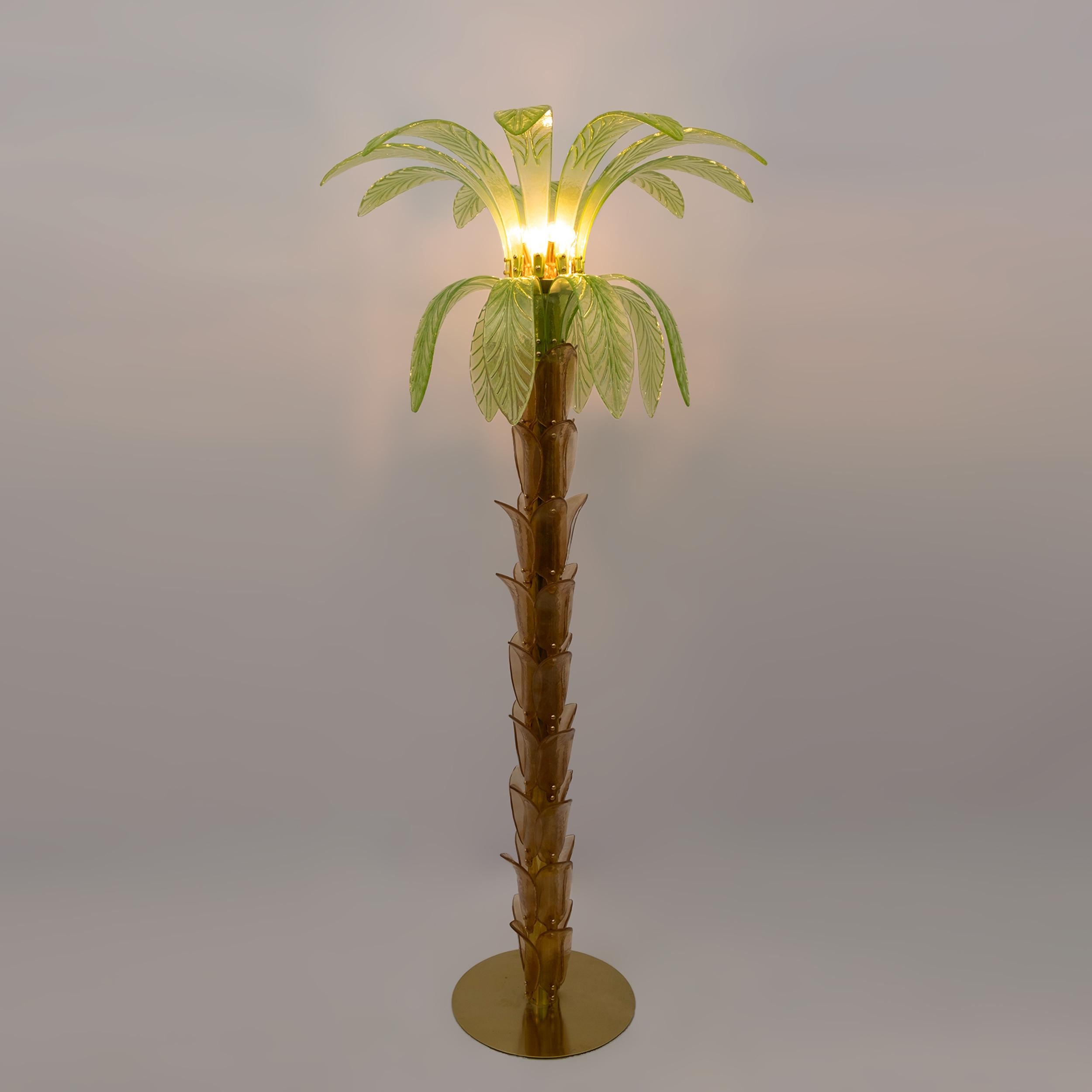 Floor lamp in amber and green Murano blown glass, the structure is in brass, four bulbs.
The floor lamp is also a sculpture that reproduces the trunk and leaves of a palm tree with pieces of glass.