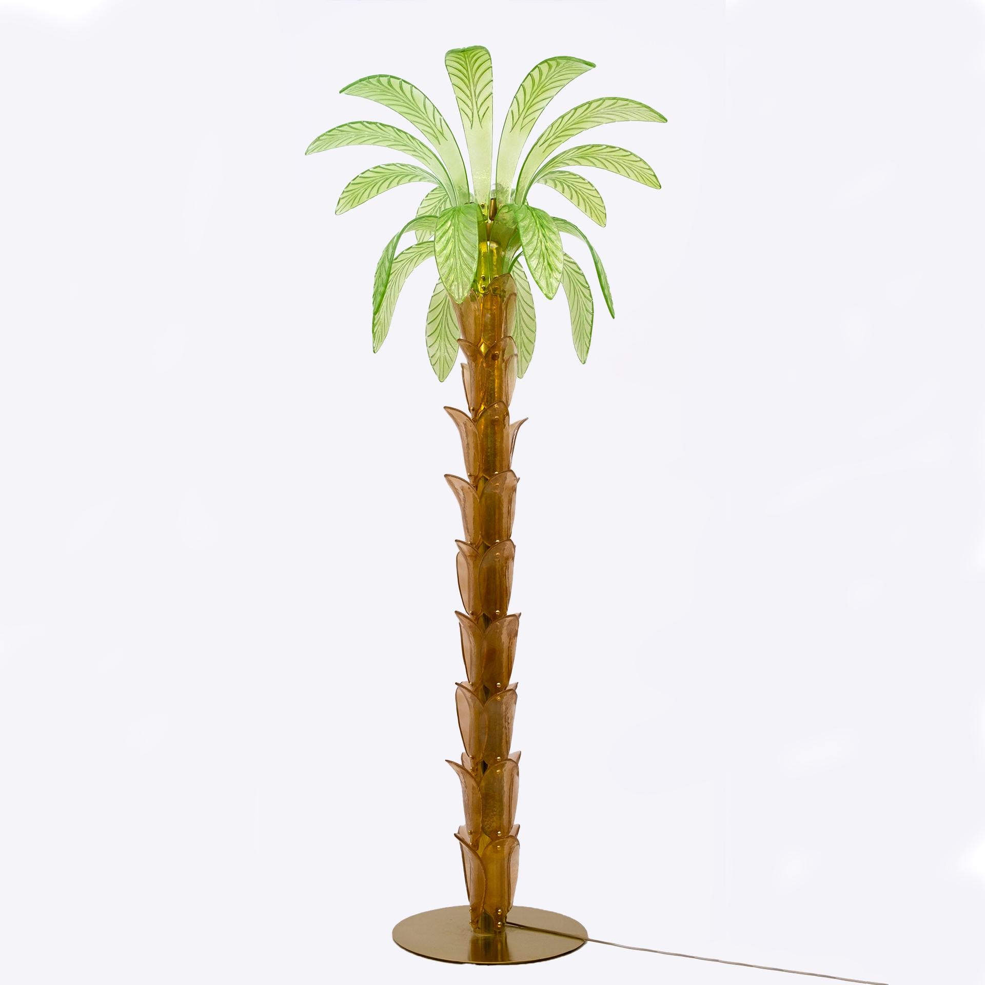 Floor lamp in amber and green Murano blown glass, the structure is in brass, four bulbs.
The floor lamp is also a sculpture that reproduces the trunk and leaves of a palm tree with pieces of glass.
