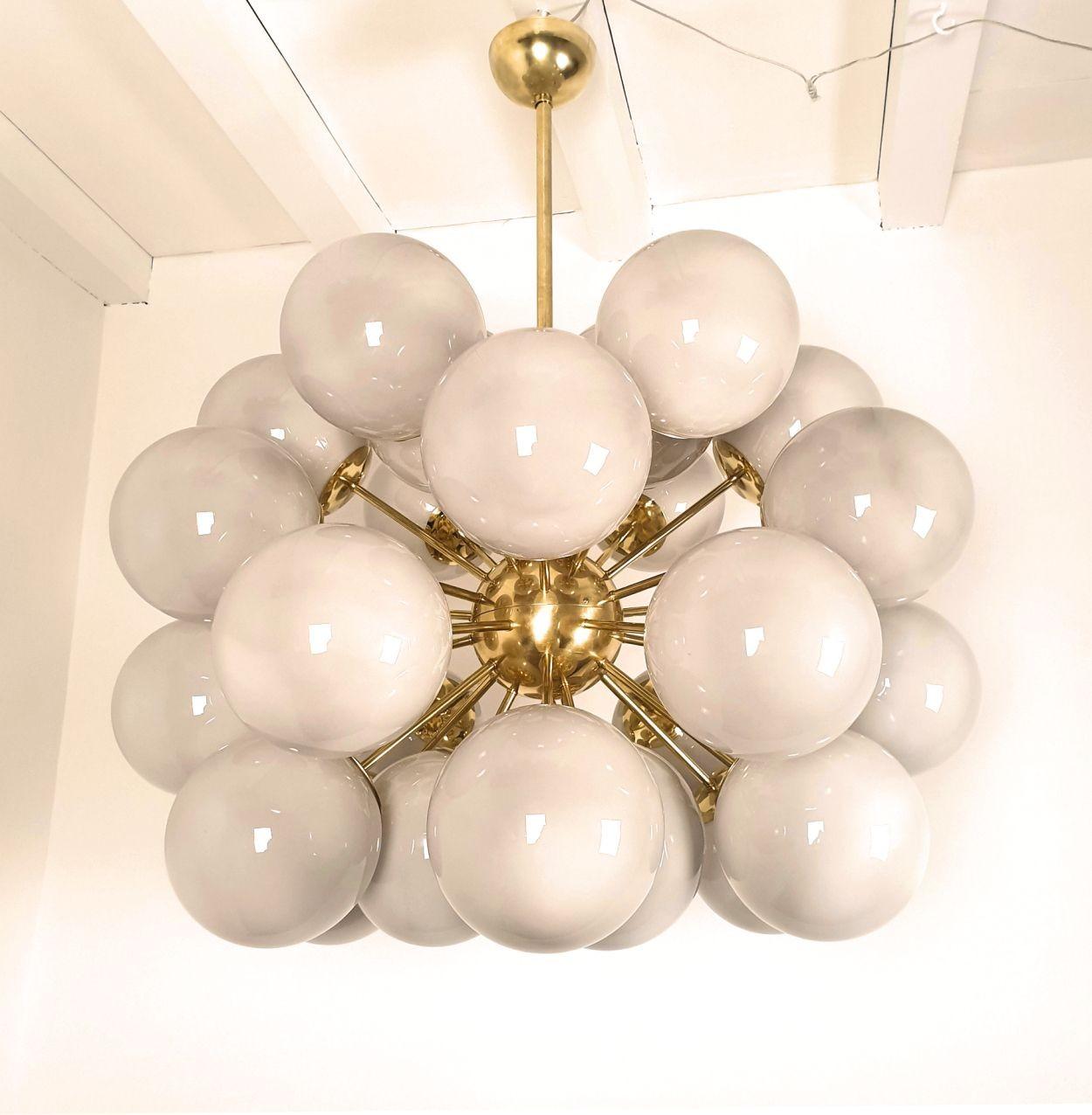 Very large Mid Century Modern light gray Murano globes Sputnik chandelier, Italy circa 1990s.
The huge vintage chandelier is made of brass mounts and 30 Murano glass globes, each nesting one light.
The glasses are translucent, in a light warm gray