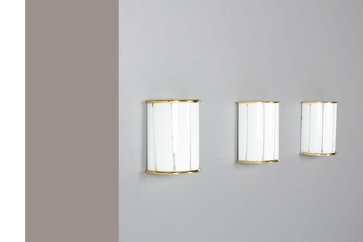 Conjunto de 3 apliques de los años 70 en Italia
Estructura de latón y reflector de cristal de Murano
Diseño chic