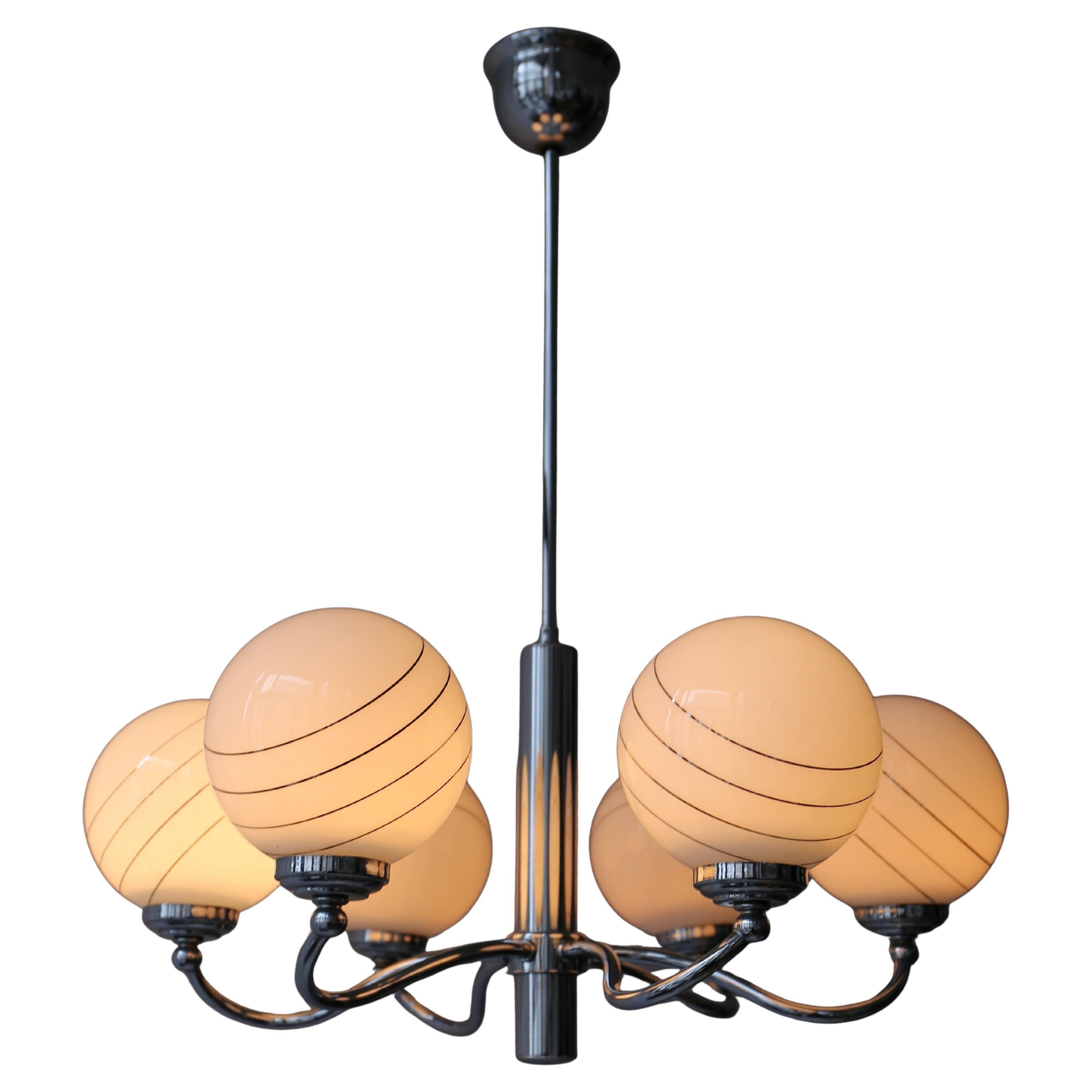 Tre lampadari italiani a sei bracci in vetro di Murano e ottone.  
Lampadario a palloncino in ottone con 6 grandi sfere opaline in vetro bianco con strisce dorate e montatura in ottone.

Misure: 
Diametro 23,6
