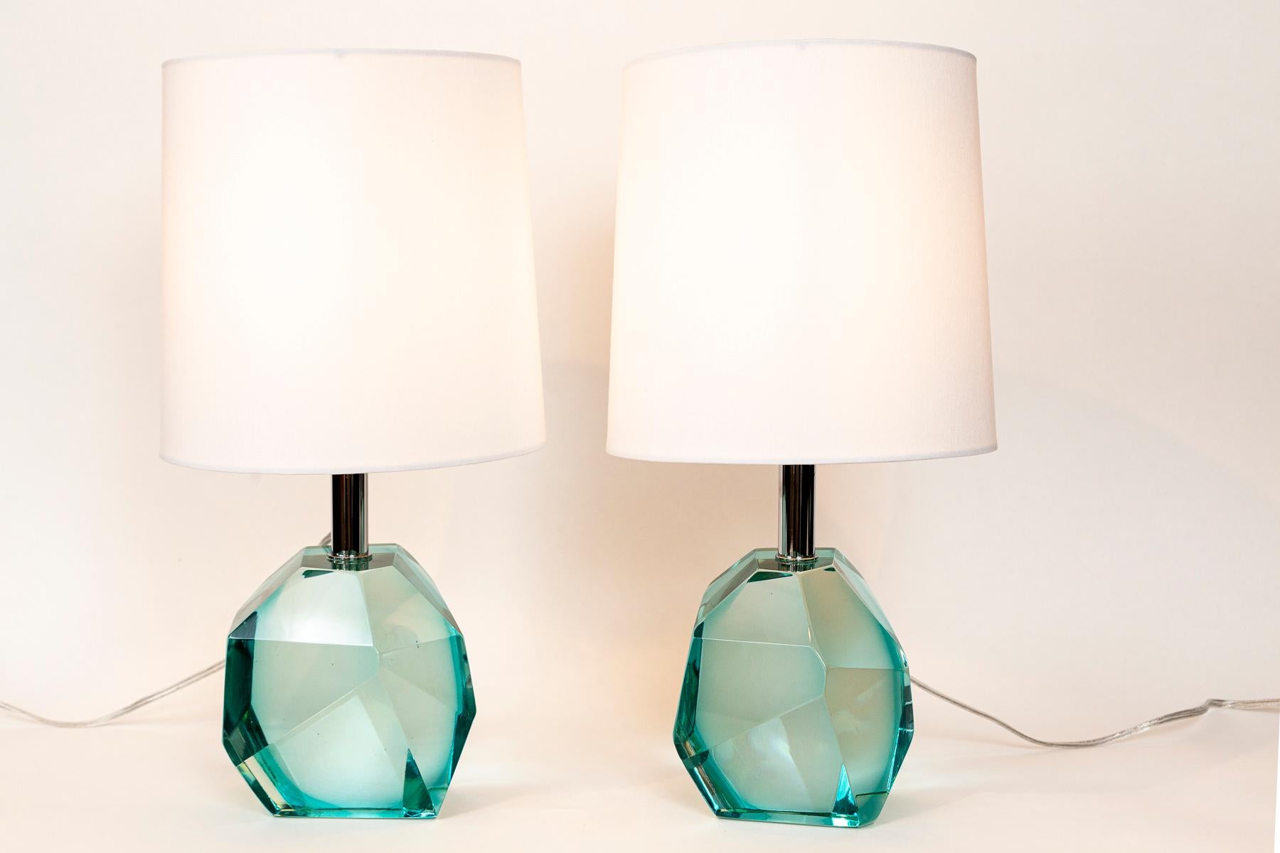 Pair of solid faceted jewel like Murano glass table lamps in a lovely transparent aquamarine color and with polished on brass nickel hardware.

Lamps sold with lampshades.

Wired to US code with and on/off switch

Origin: Murano, Italy and signed by