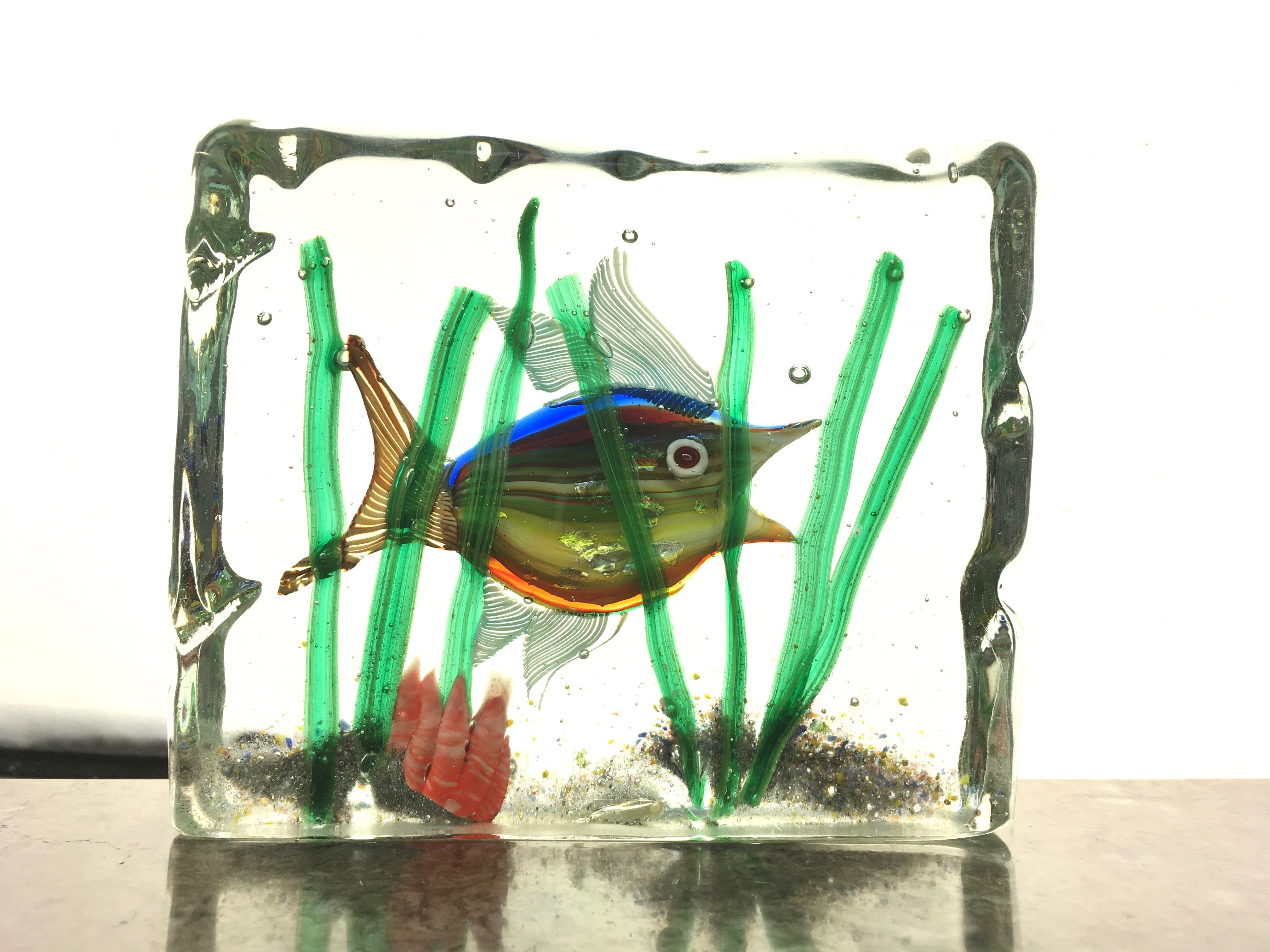 Super cute 1950s-1960s aquarium paperweight by Alfredo Barbini for Cenedese, Murano.

Lovely flecks of silver foil with latticino fins on a perky little fish with striped multicolored body.

All in a beautiful setting - sand, pink coral, seagrass