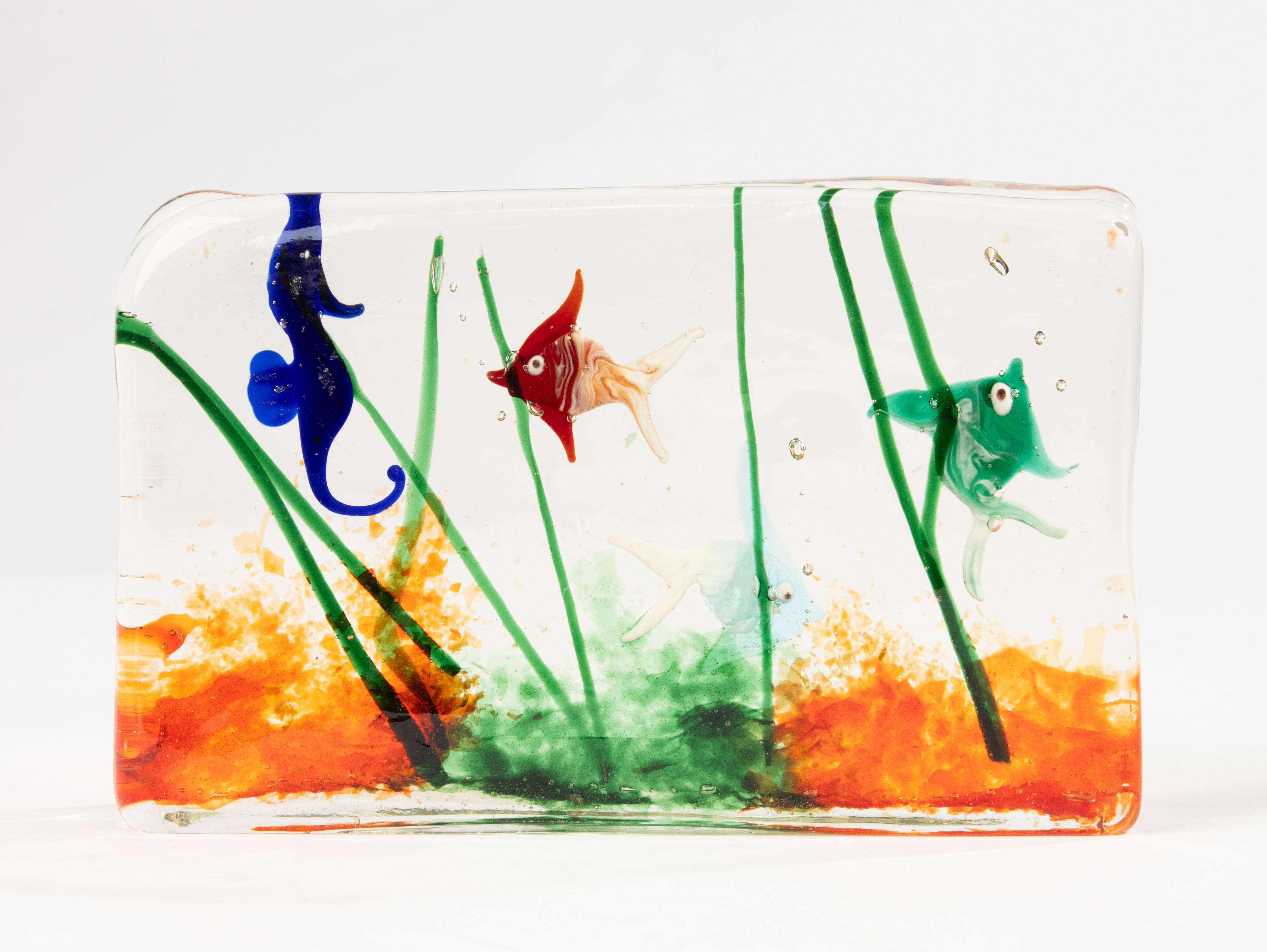 Vibrante sculpture d'aquarium en verre de Murano soufflé à la main, datant probablement des années 1960. Ce bloc décoratif présente des poissons colorés et des plantes aquatiques enfermés dans du verre transparent, mettant en valeur le savoir-faire