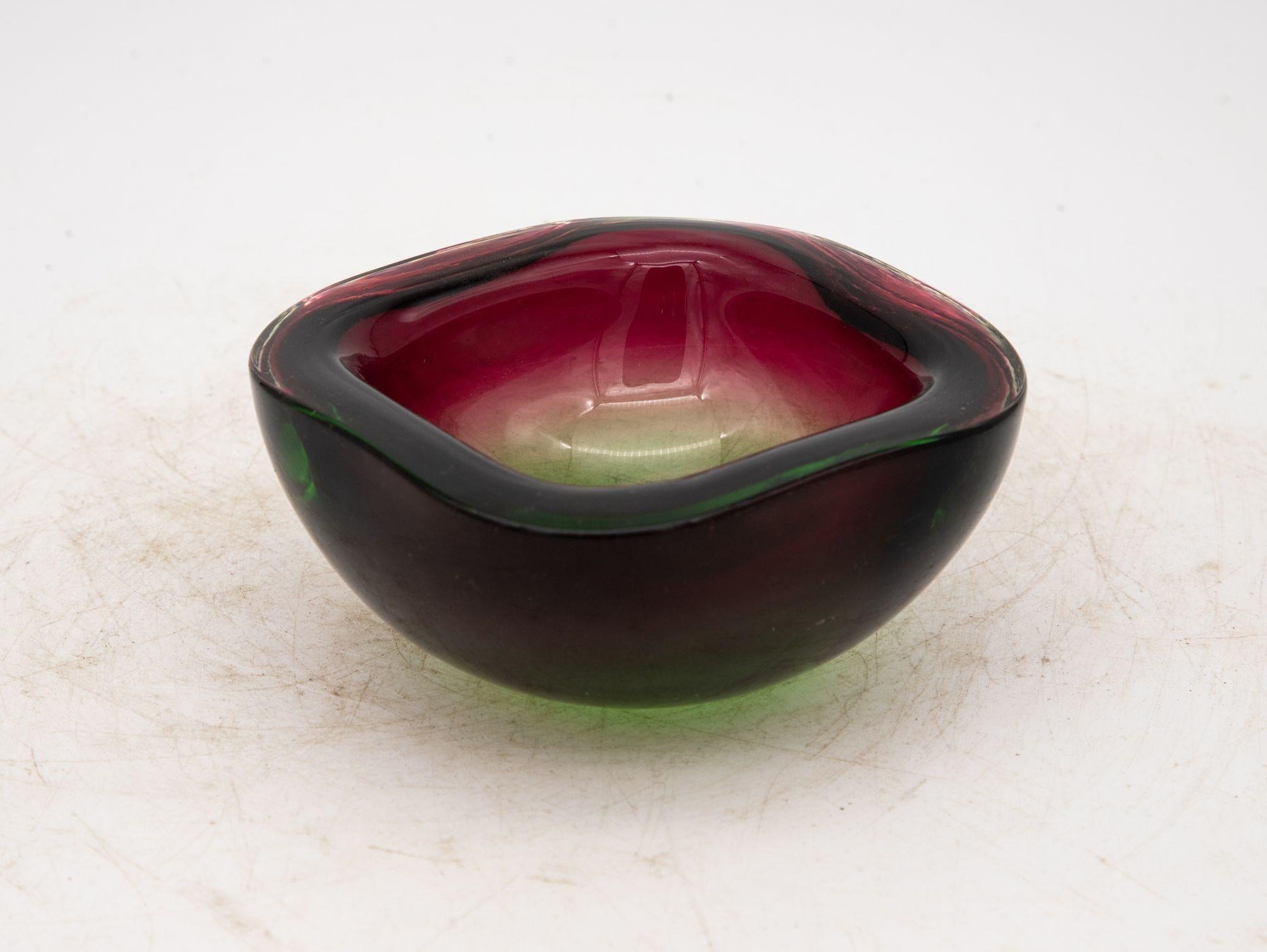 Crafted in the vibrant spirit of the 1960s, this Murano glass ashtray exudes timeless charm. With its square shape and gently rounded corners, the thick glass construction boasts both sturdiness and elegance. The color palette, a mesmerizing