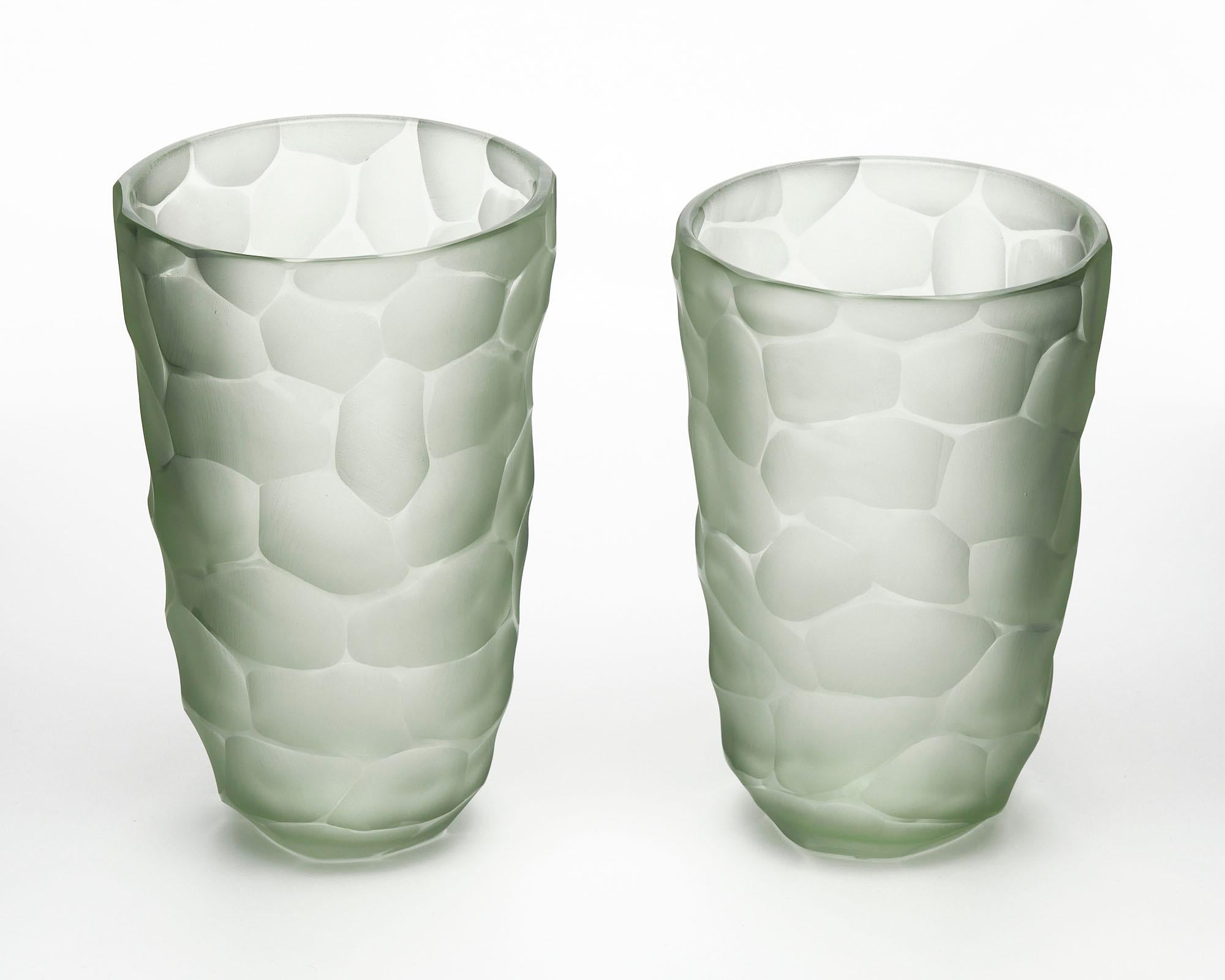 A pair of vases made of hand-blown glass from the Island of Murano outside of Venice, Italy. This pair has a light sea glass color and are made using the 