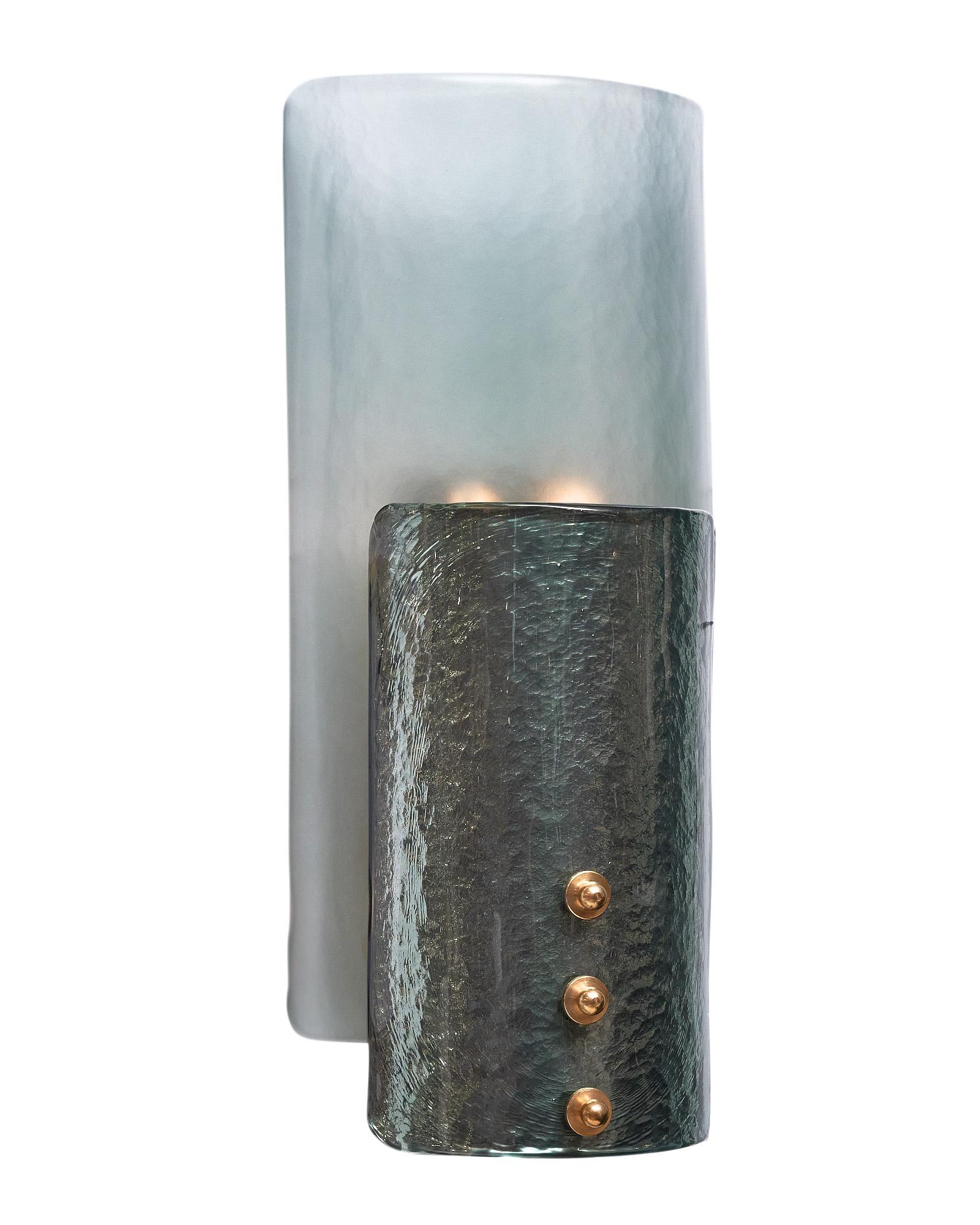 Pair of sconces made of Murano glass in a striking “bleu pétrole” color. This pair is crafted of molded glass from the island of Murano outside of Venice, Italy. There are  two glass components to the sconces - the bottom layer is a light blue