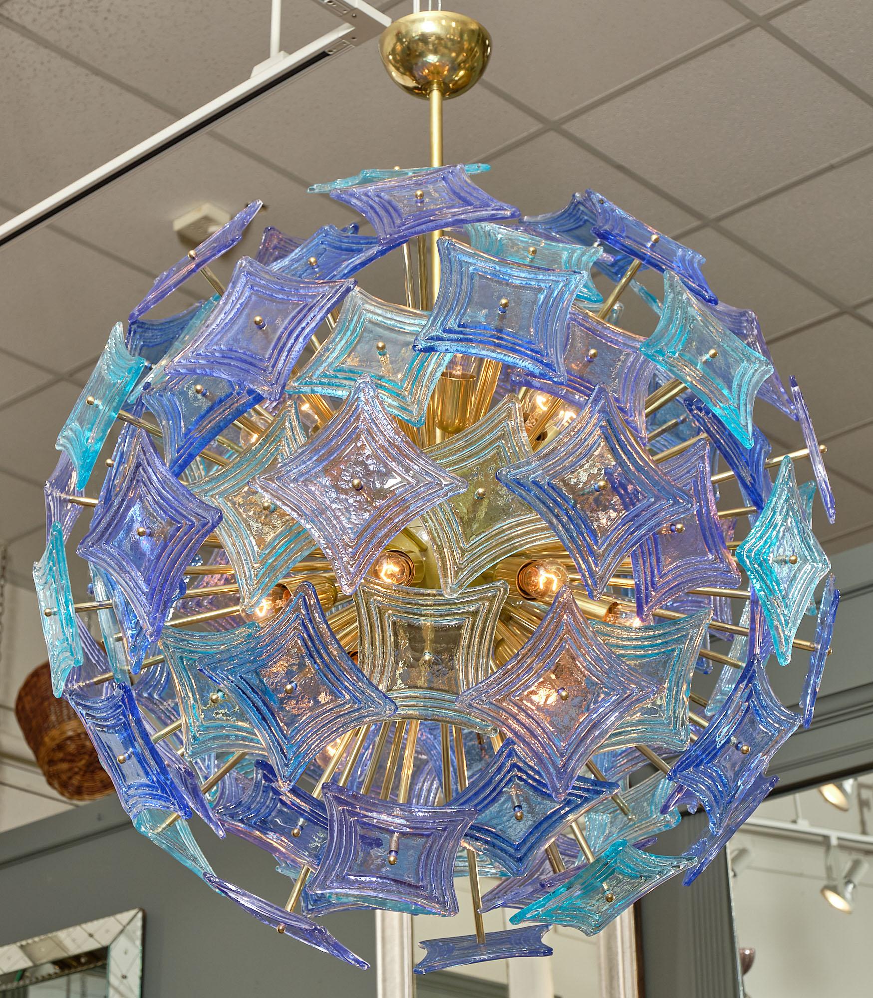 A Murano glass “sputnik” chandelier featuring multiple purple and blue square ridged components. They are supported by a gilt brass structure. This hand-blown fixture has been newly wired to fit US standards.

This piece is a special order from