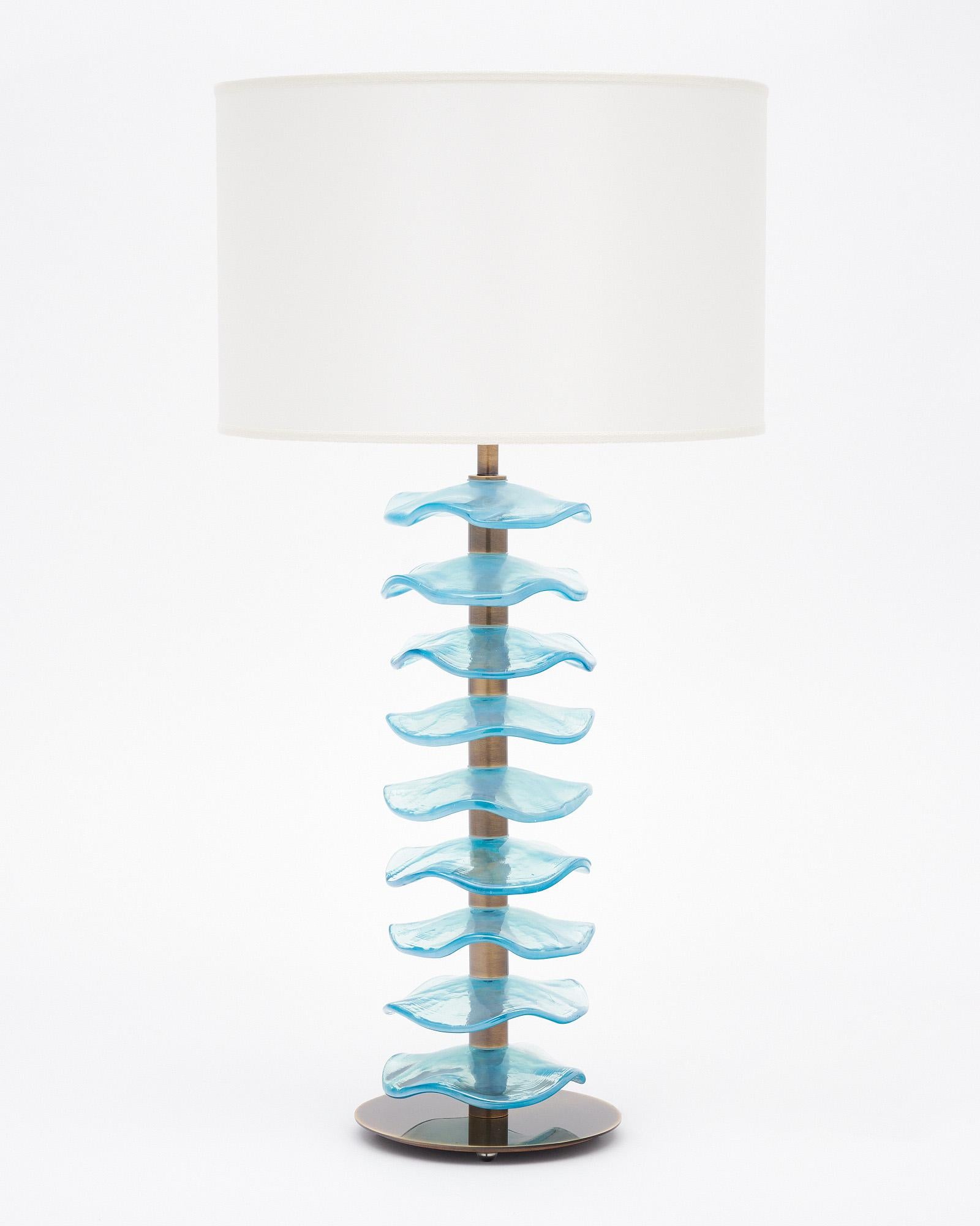 Pair of Italian lamps made of Murano glass. This pair boasts iridescent blue glass discs featured along  a brass stem. They are hand-crafted and have been newly wired to fit US standards. 
