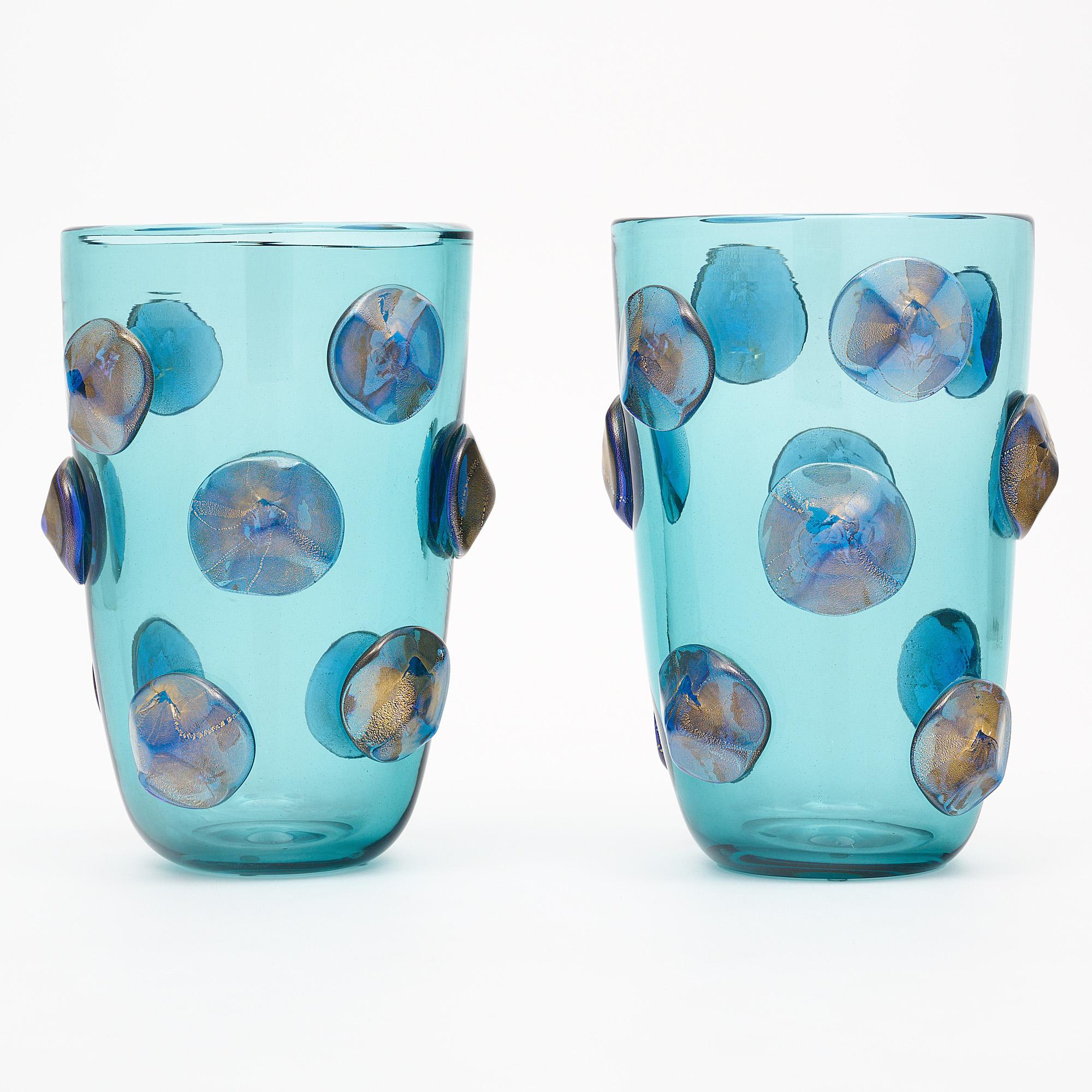 Murano glass medallion vases made of blue glass with 23 carat gold leaf flecks in the cobalt blue glass that makes up the medallions. We love this hand-blown and crafted pair. They are signed by Murano maestro Alberto Dona.