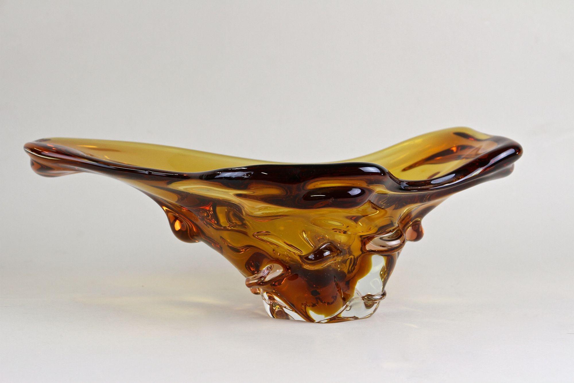 Extraordinaire coupe en verre de Murano sortant des célèbres ateliers d'Italie et datant de la période autour de 1960/70. Coloré dans un magnifique ton ambré/brun, ce bol en verre contemporain de forme très inhabituelle impressionne par son design