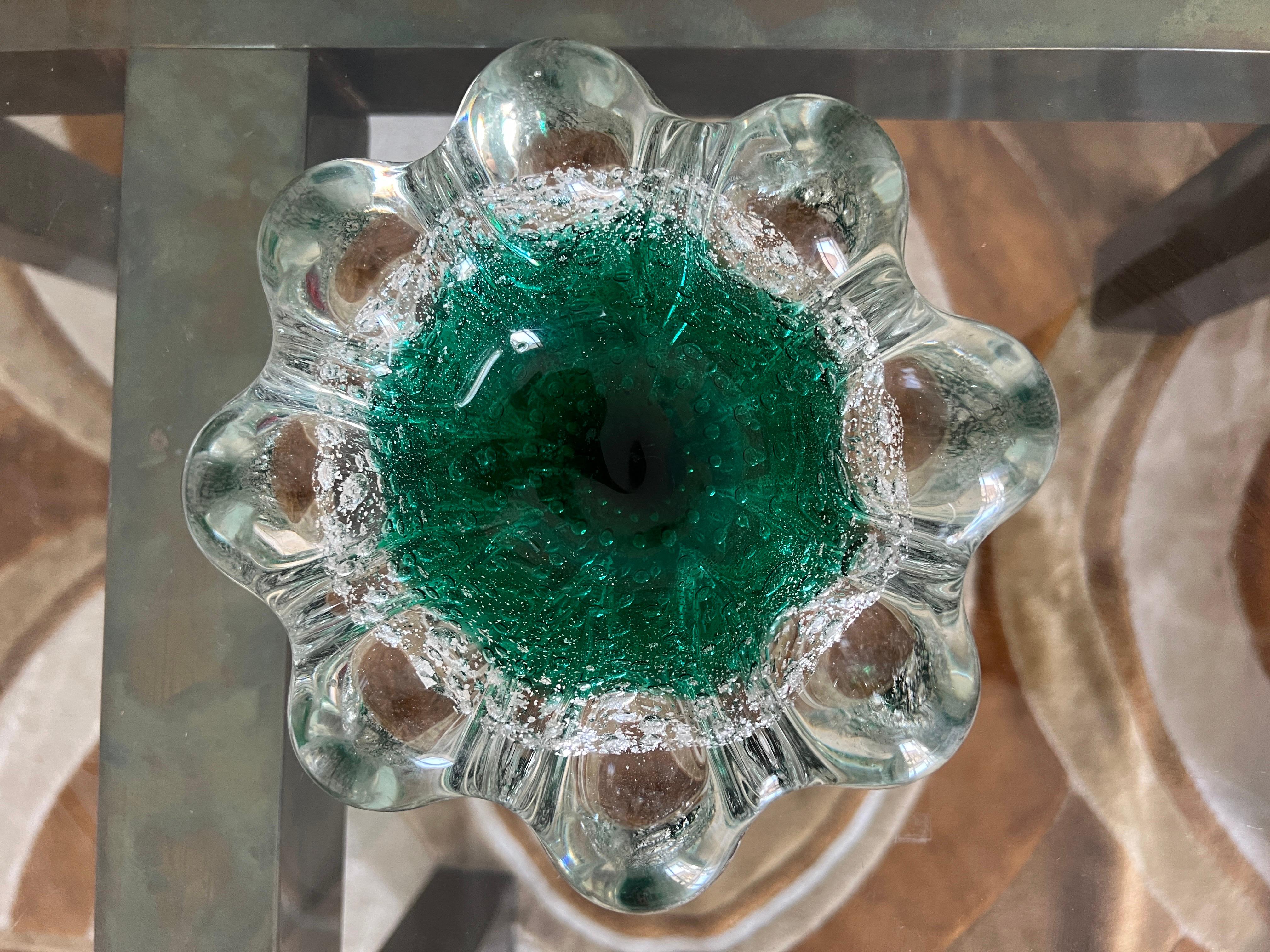 Presenting a stunning Murano glass piece by Seguso from the 1970s – a bowl or ashtray showcasing the renowned craftsmanship of the Seguso artisans. This exquisite piece features a blend of transparent to emerald green glass.. Within the glass,