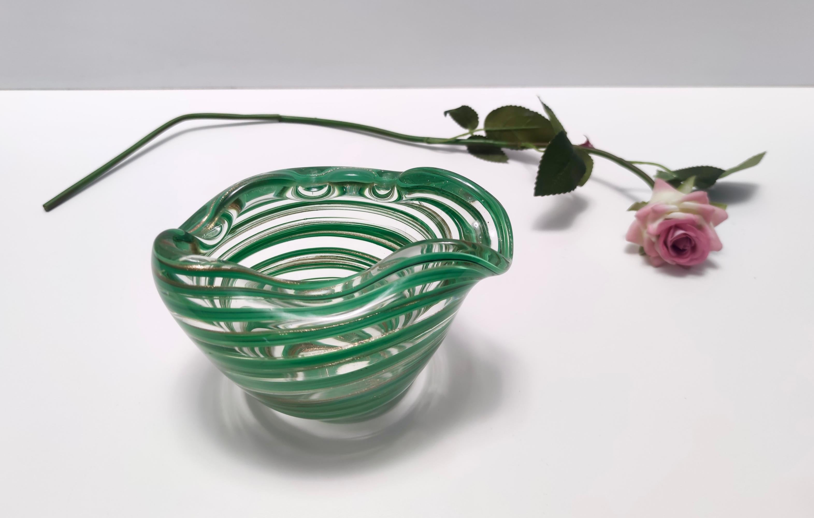 Made in Italy, 1950s. 
This is a thick Murano glass bowl / ashtray / vide-poche ascribable to Alfredo Barbini because of its wavy rims. 
It is made with Murano glass and green canes with aventurine glass. 
This is a vintage piece, therefore it might