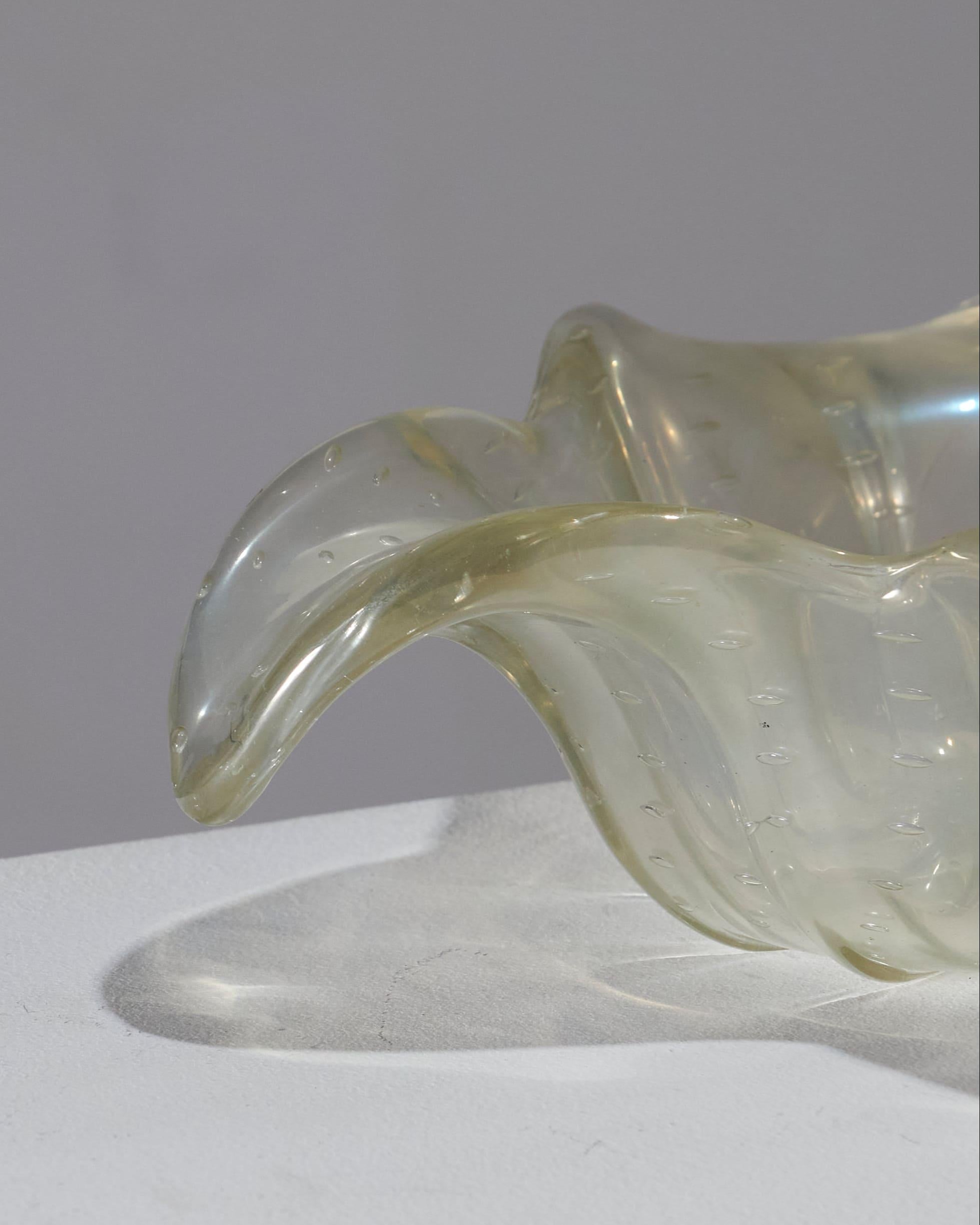 Auffangschale aus Murano-Glas mit Goldflecken, für Barovier & Toso, 1940er Jahre.
Dieses dicke, mit Blasen durchzogene Glasstück in Form einer Muschel wurde mit einer Zange heiß bearbeitet und mit einem schimmernden Regen aus Blattgold überzogen.