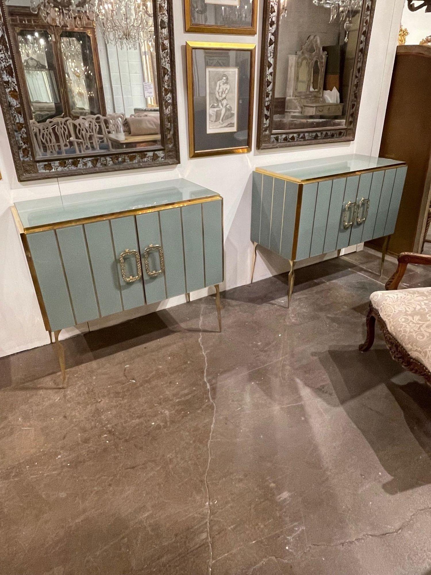 Fabulous pair of Murano glass and brass side cabinets in a pale green. Nice brass details and a shelf inside for storage. Creates a very upscale modern look. Stunning!