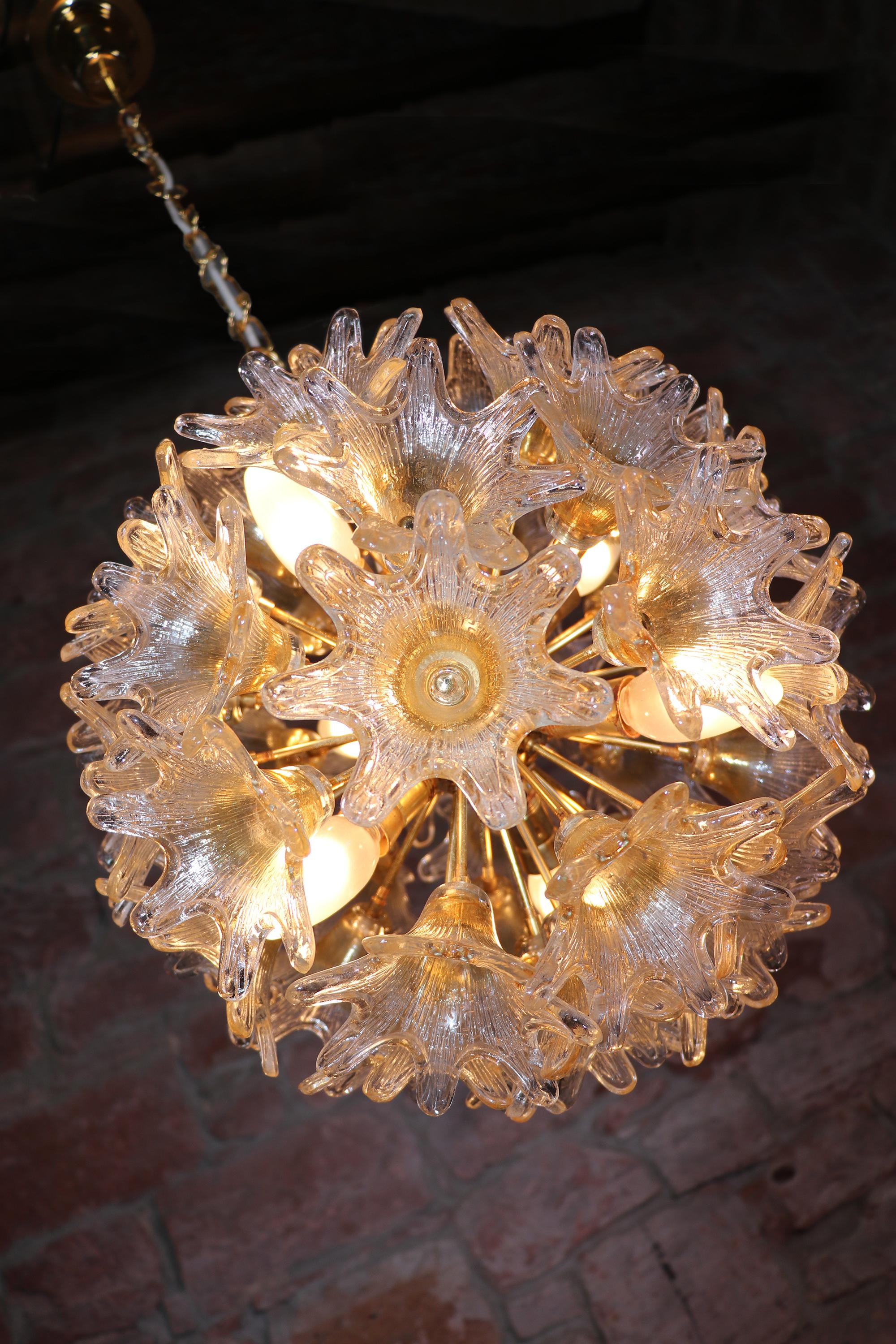 Elegant sputnik chandelier with star-shaped amber glass flowers on a gilded brass frame. Designed by Paolo Venini. Star-shaped glasses resembles flowers. Chandelier illuminates beautifully and offers a lot of light. Newly rewired with six sockets.