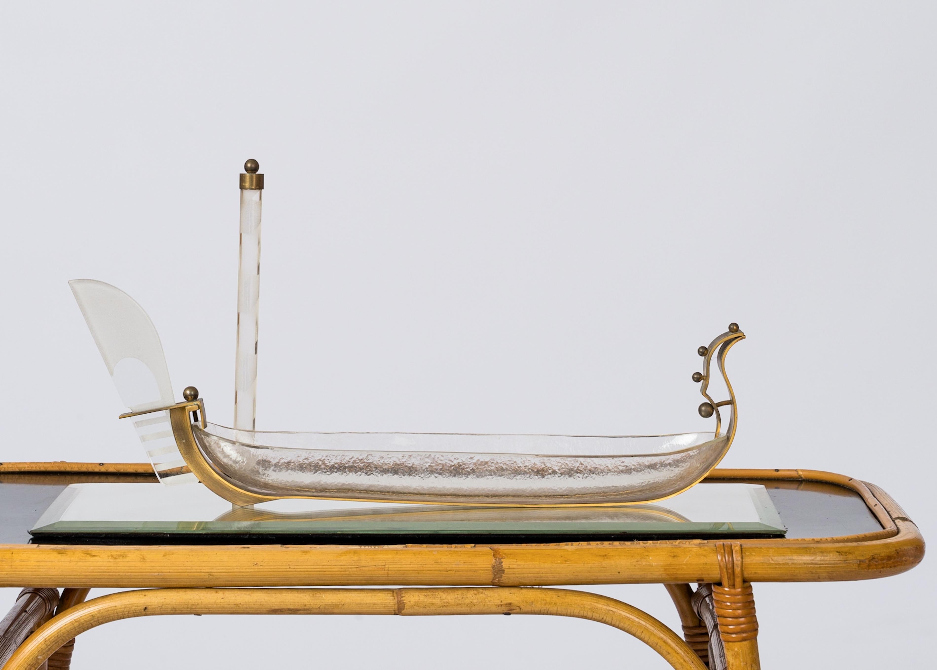 Einzigartiger Tafelaufsatz mit einer außergewöhnlichen Gondel aus strukturiertem Murano-Glas, die auf einem rechteckigen, abgeschrägten Spiegelsockel steht. Der Spiegelsockel ist mit einem kreisförmigen Loch aus Bronze versehen, in das eine