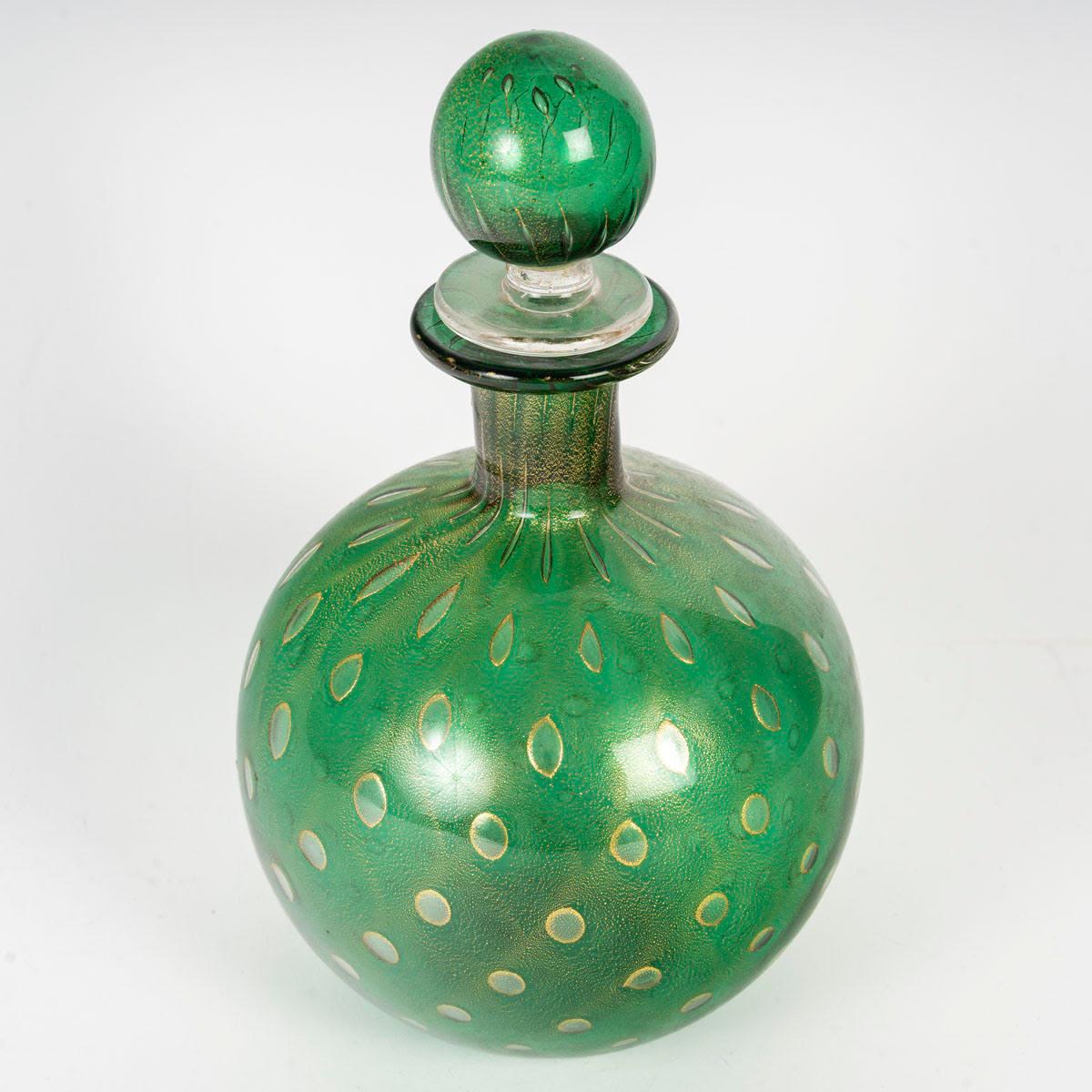 Caraffa in vetro di Murano, oro iridescente, XX secolo.

Bottiglia e caraffa in vetro di Murano, arte moderna, XX secolo.
H. 21cm, P. 13cm