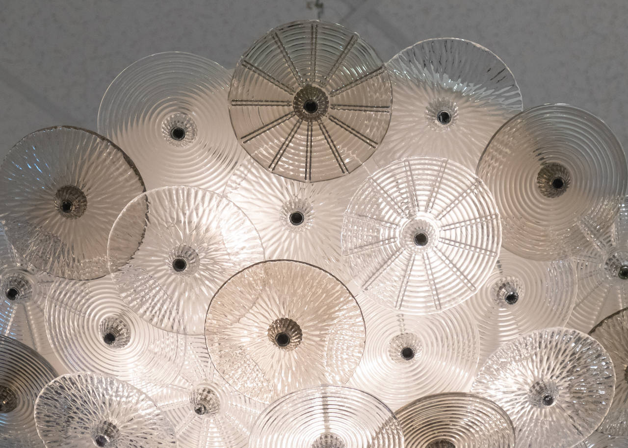 Espectacular lámpara de techo empotrable de cristal de Murano con treinta y cinco discos de cristal transparente y ahumado de distintos motivos y texturas con remates de cristal. Una hermosa pieza icónica al estilo de Carlo Nason. Cableado conforme