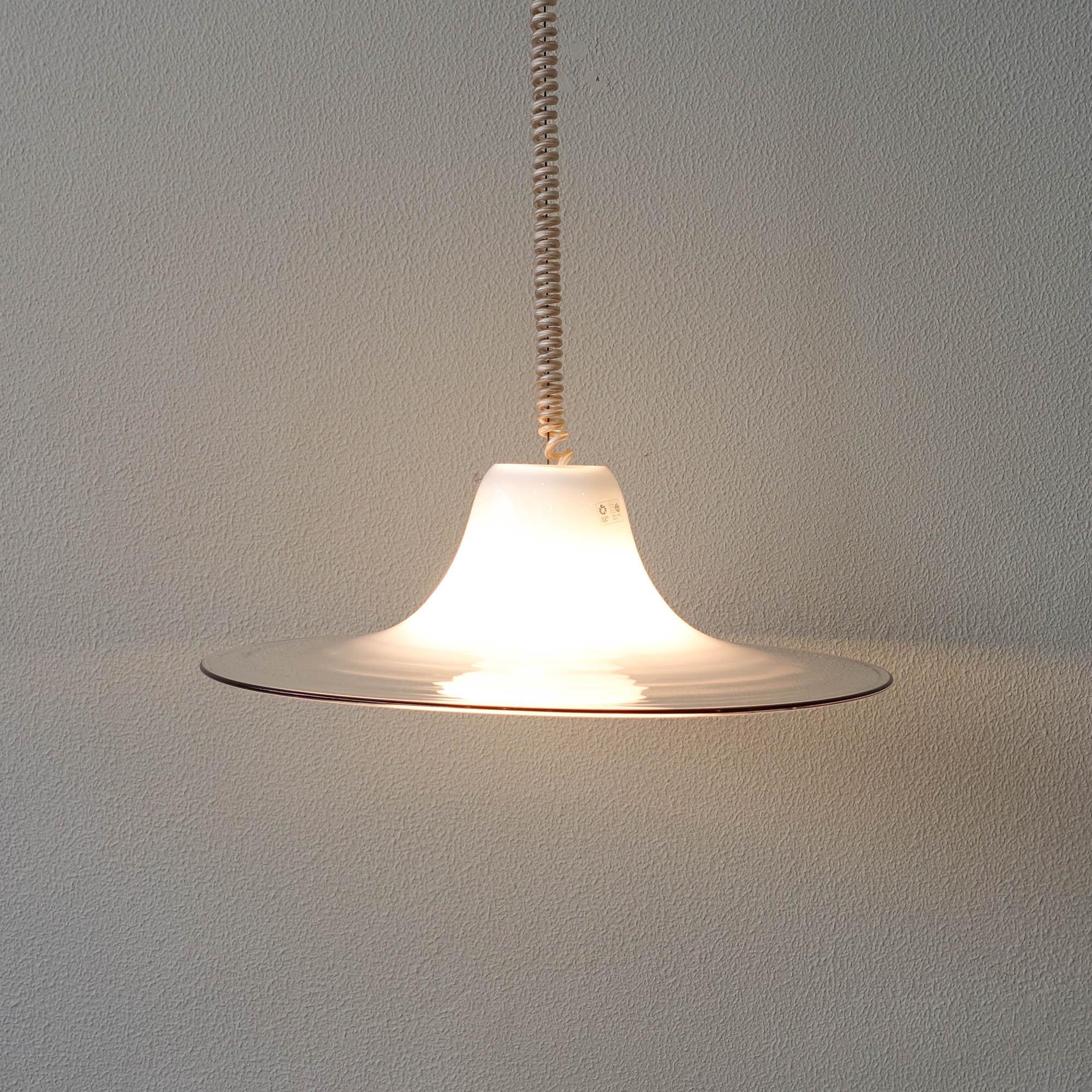 This pendant lamp was designed by Renato Toso and produced by Leucos in Italy, during the 1970's. It is made of a thick piece of murano glass, that goes from opaline white to transparent. With the original label of the manufacture and marked also on