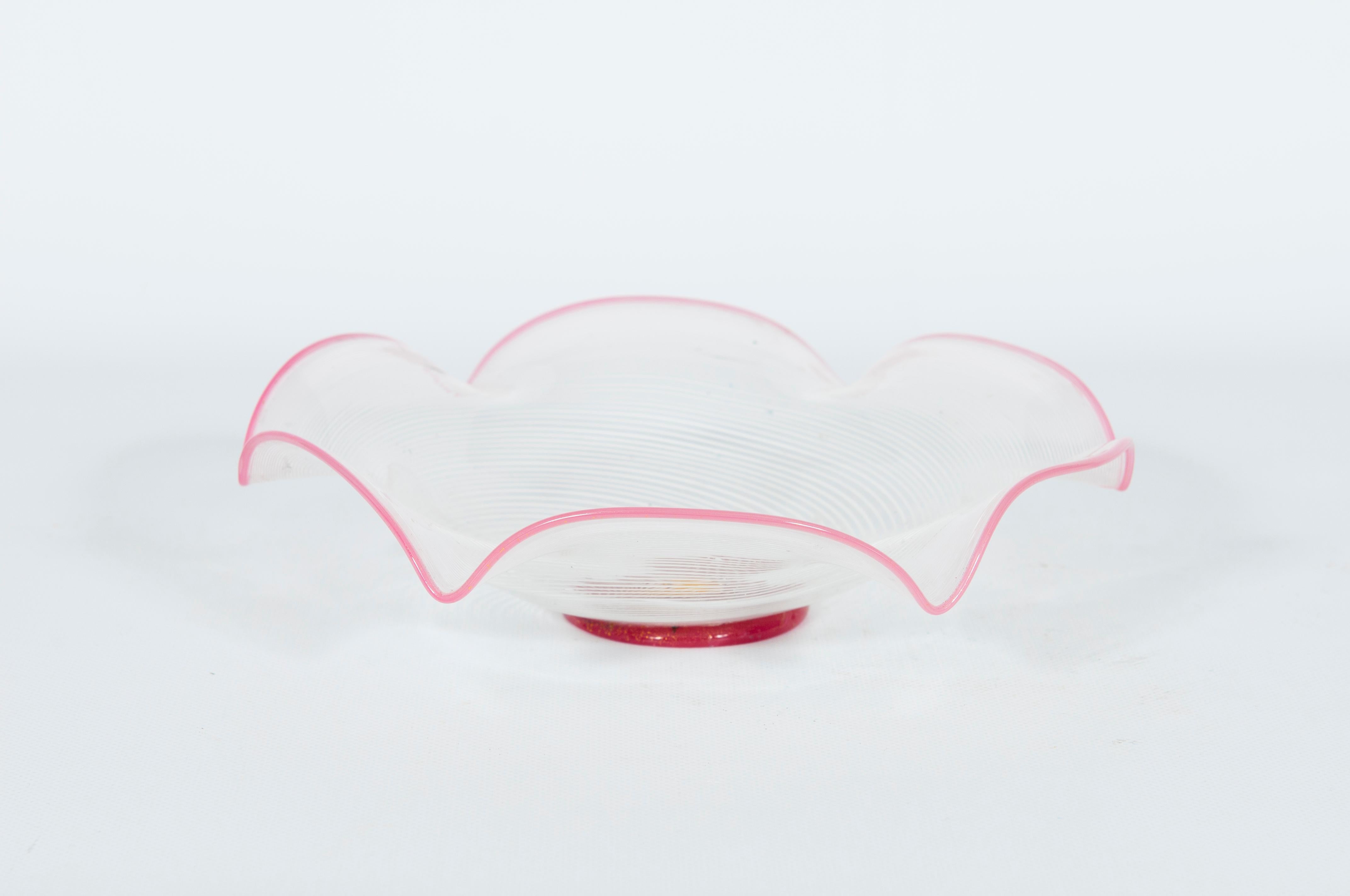 Este elegante centro de mesa de cristal de Murano, creado en la década de 1960, es un bello ejemplo del diseño moderno italiano de mediados de siglo. El cuenco presenta un delicado borde ondulado de un vibrante tono rosa, que le da una forma suave y