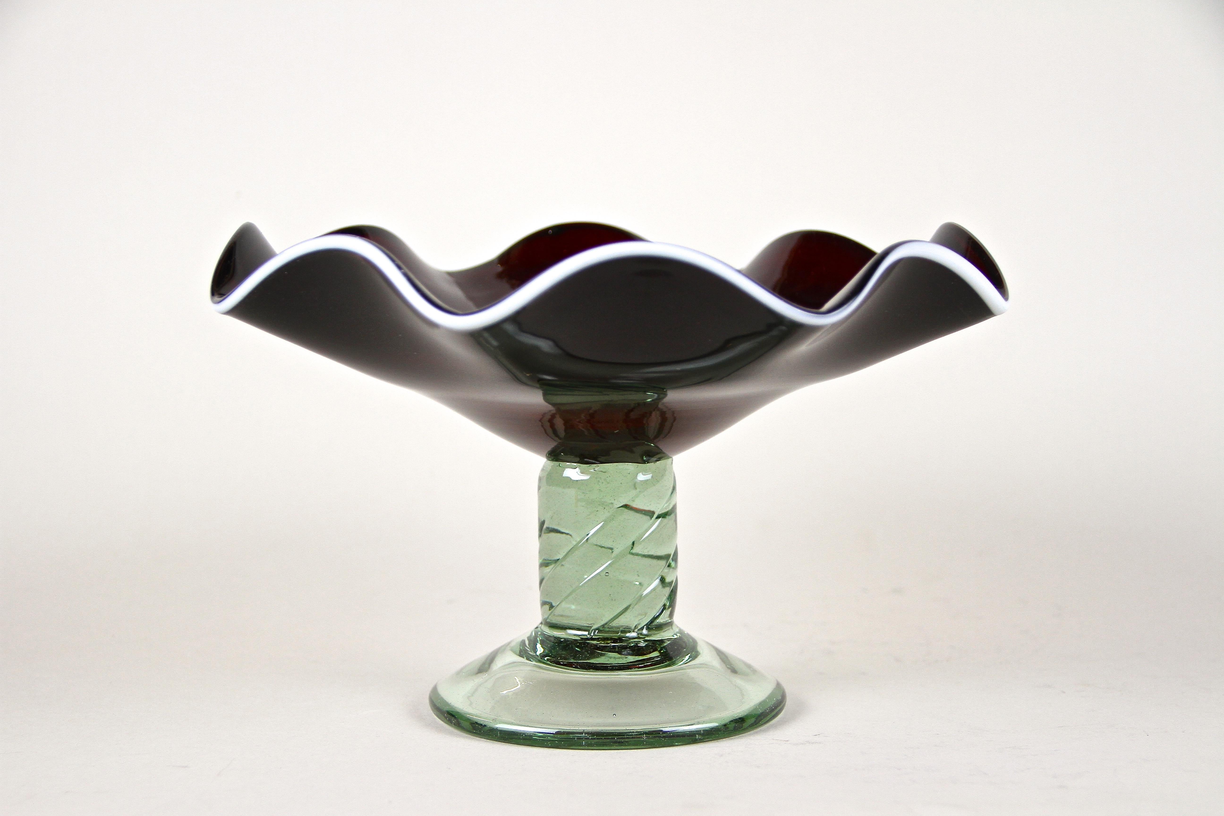 Wunderschöne Muranoglasschale aus Italien aus dem späten 20. Jahrhundert um 1970. Ein ungewöhnliches Stück Murano-Glaskunst mit toll geformter, super dunkelroter, fast schwarz aussehender, gewellter Glasschale. Verziert mit einem zusätzlichen zarten