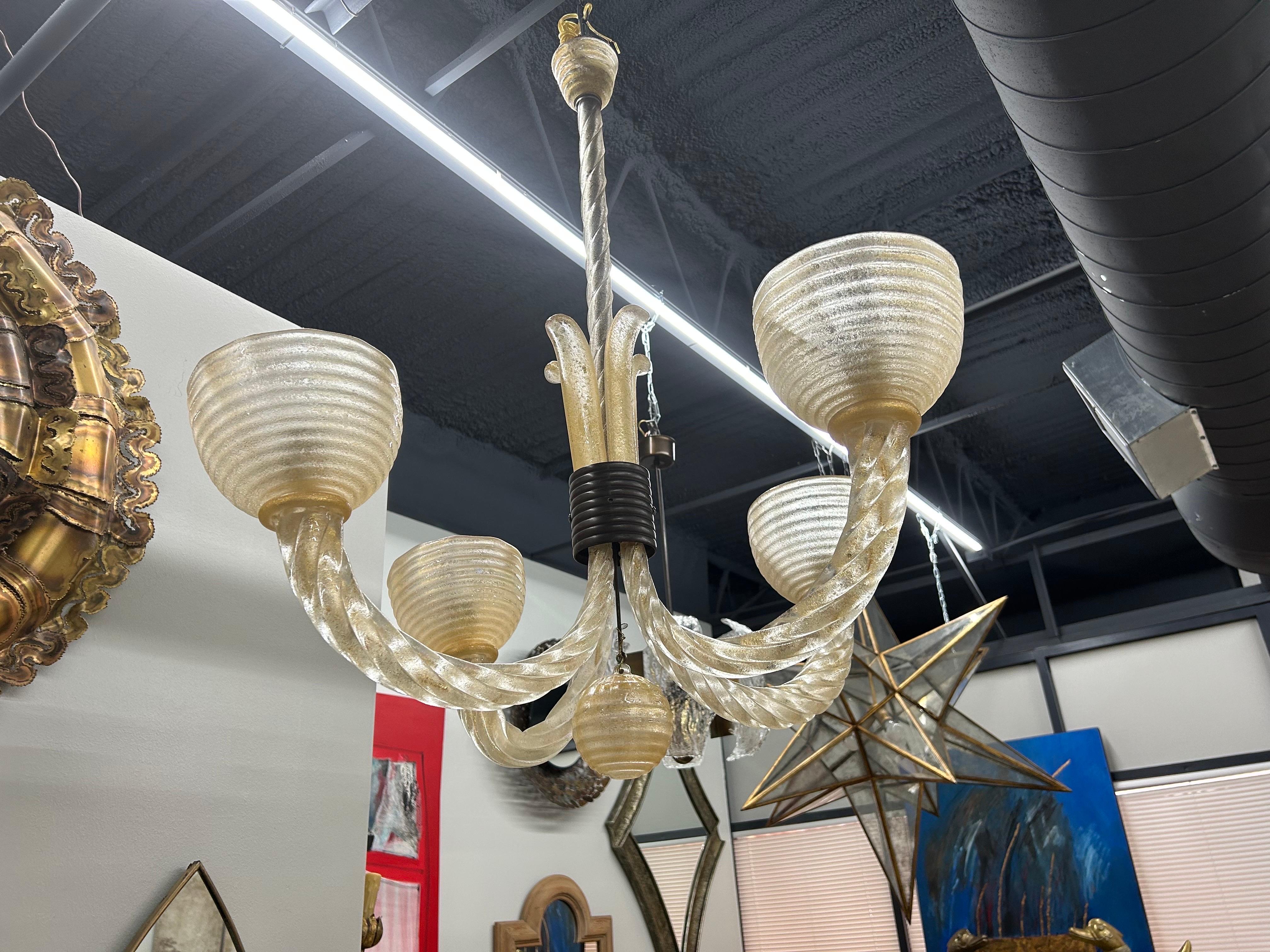 Murano Glass Chandelier By Barovier.
We offer a beautiful 4 light Murano glass chandelier designed by Ercole Barovier in the 1940's. This lovely Art Deco Murano chandelier has graceful twisted glass arms with striated glass shades. Our chandelier