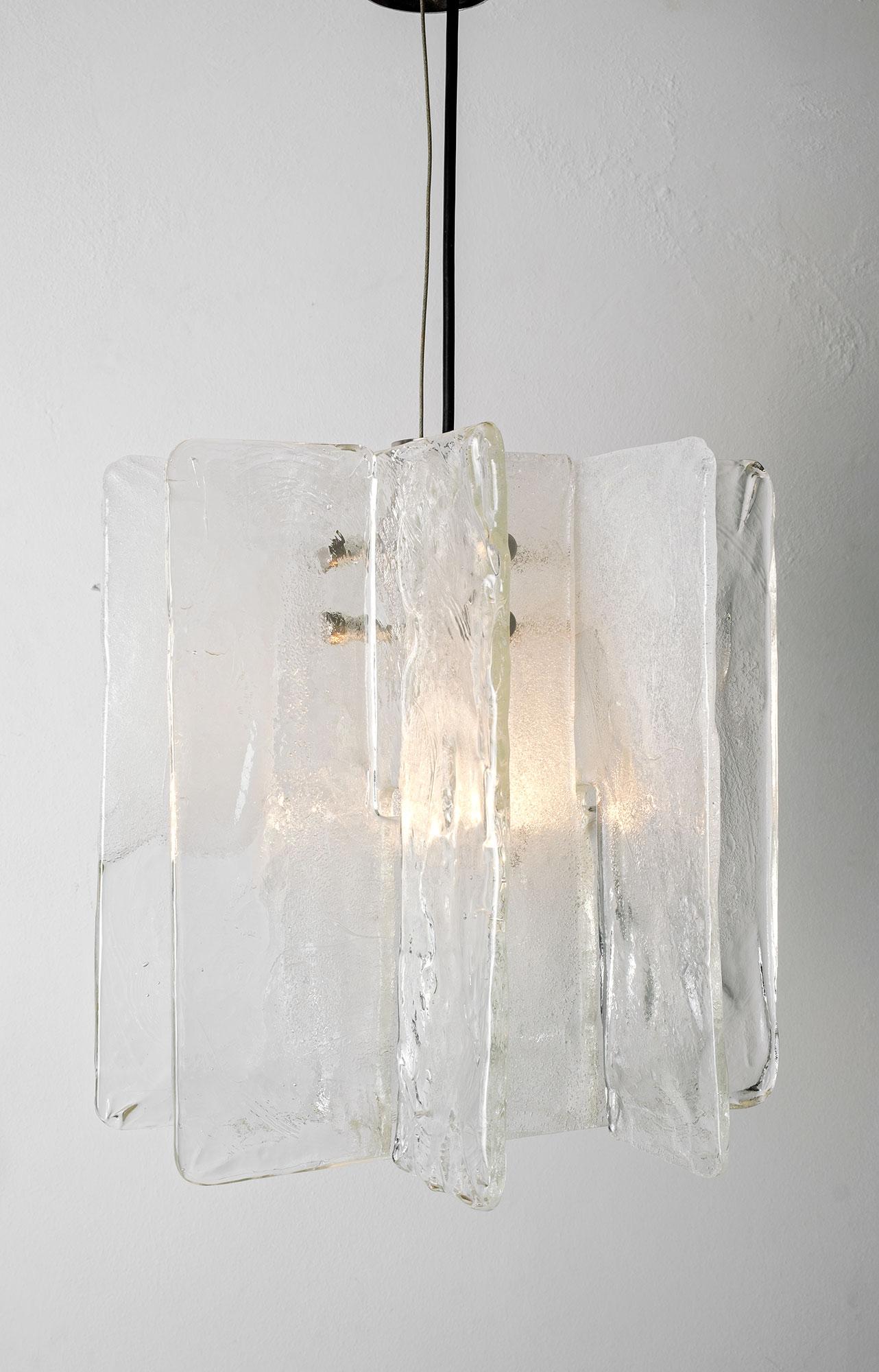 Stunning Murano glass chandelier designed by Carlo Nason for Mazzega, Italy, from the 1970s. 
The chandelier is made of 4 thick white and transparent handblown Murano glass elements attached to a metal frame. Beautiful piece creating a great light