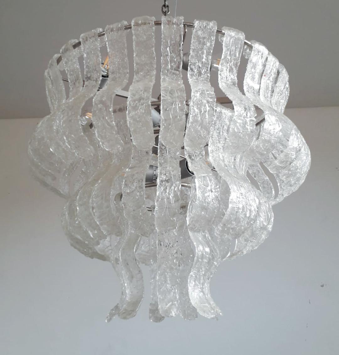 Vintage Italian chandelier with layered clear curved textured Murano glass panels / Made in Italy by La Murrina, circa 1960s
14 lights / E26 or E27 type / max 60W each
Measures: Diameter 25.5 inches / height 21.5 inches plus chain and canopy
1