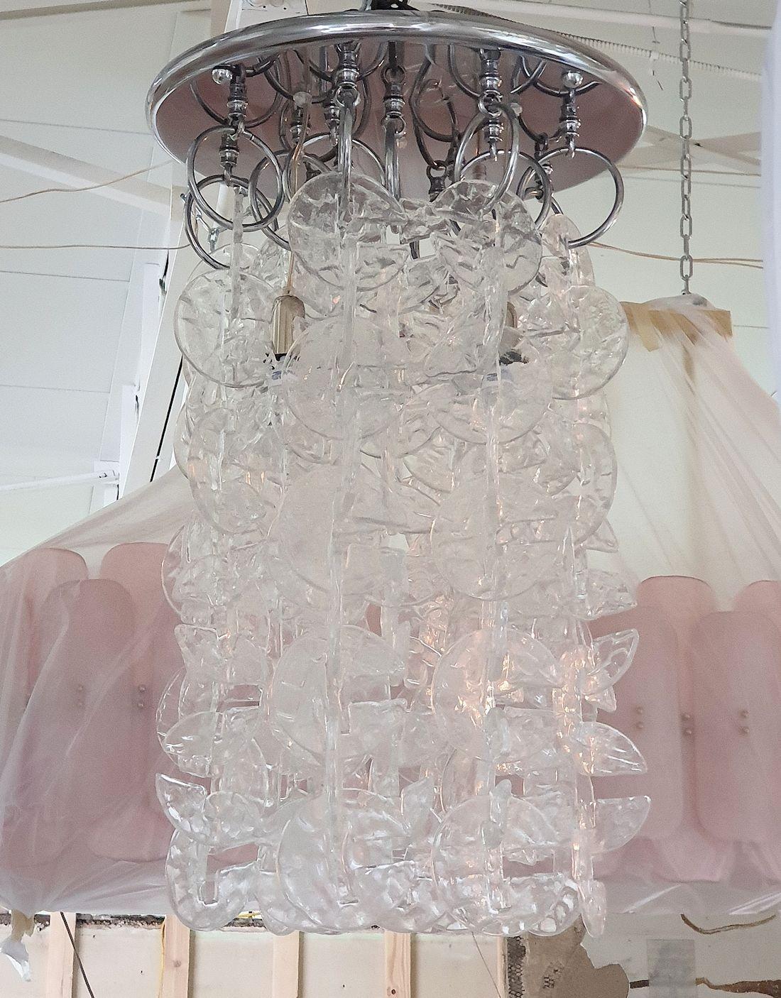 Grand lustre encastré, ou lampe suspendue, du milieu du siècle dernier, par Mazzega, Italie, années 1970.
L'encastrement vintage est composé de supports chromés et de crochets ronds en verre de Murano, transparents et translucides, en forme de