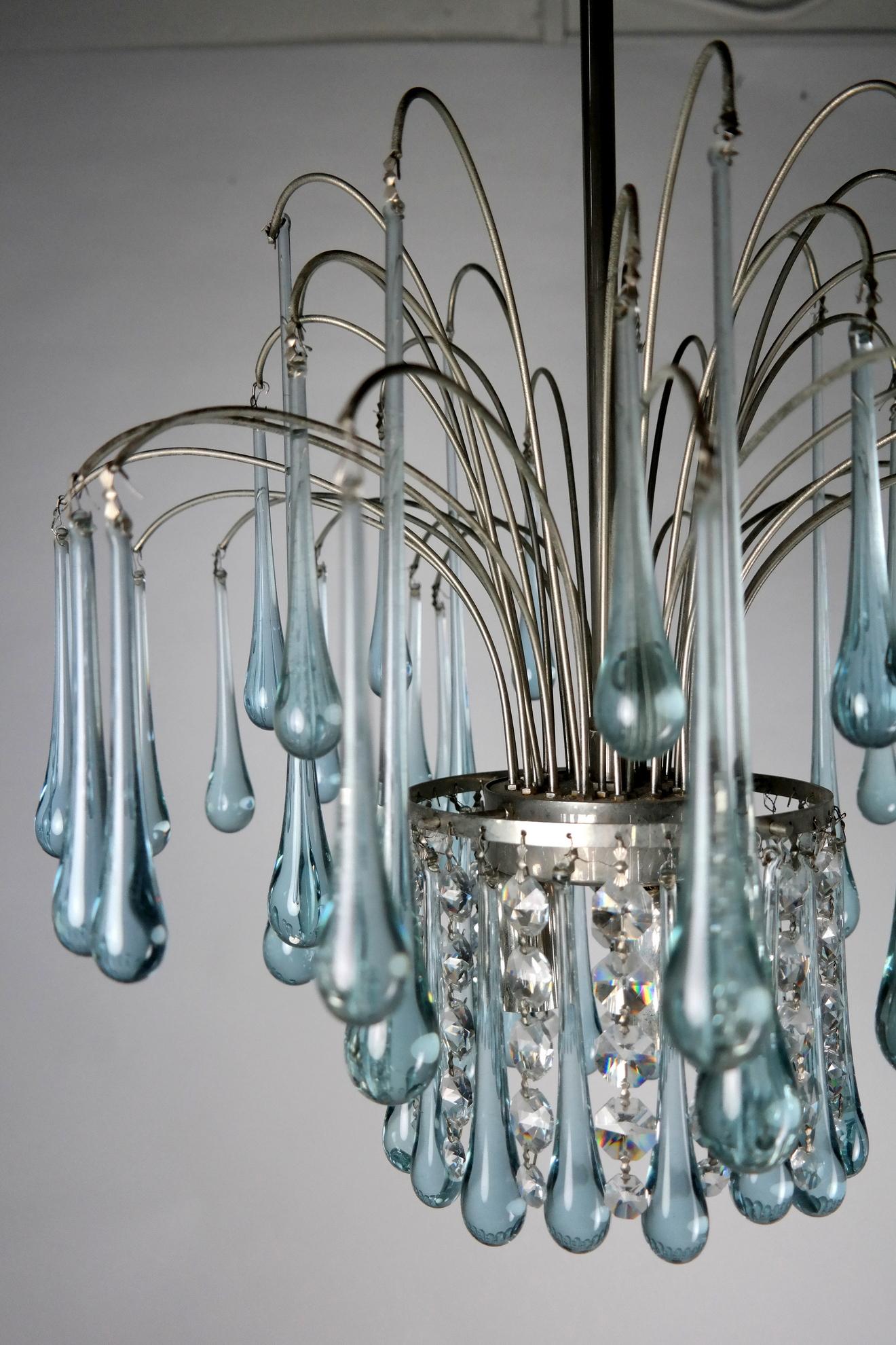 Incantevole lampadario in vetro di Murano azzurro del famoso designer Paolo Venini, degli anni Sessanta. Il corpo placcato in nichel presenta una leggera usura, coerente con l'età e l'uso.