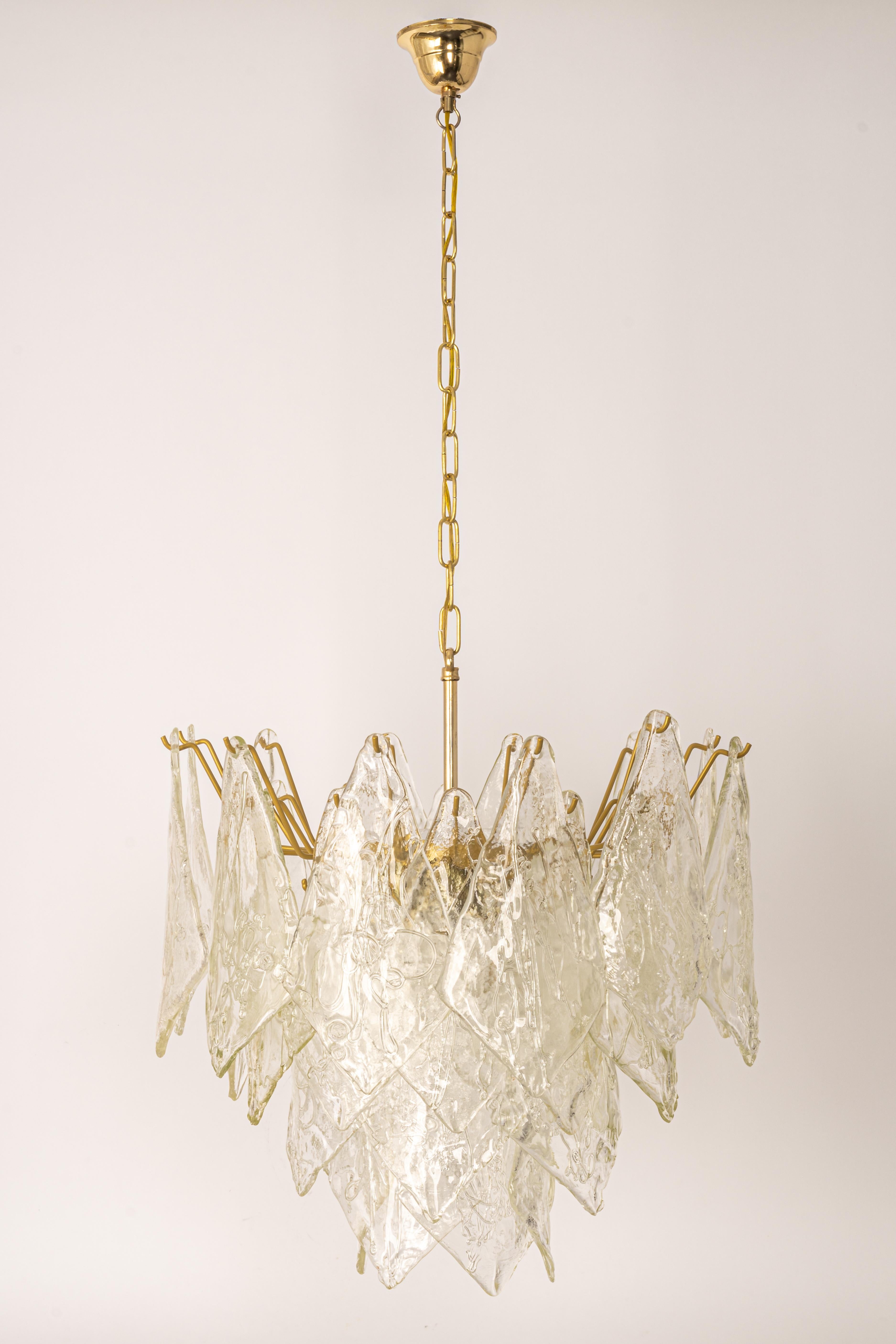 A stunning Murano glass chandelier designed by Carlo Nason for Mazzega, Italy, manufactured in the 1970s.
The chandelier is composed of 19 thick textured glass elements attached to a brass metal frame.

High quality, very good condition. Cleaned,