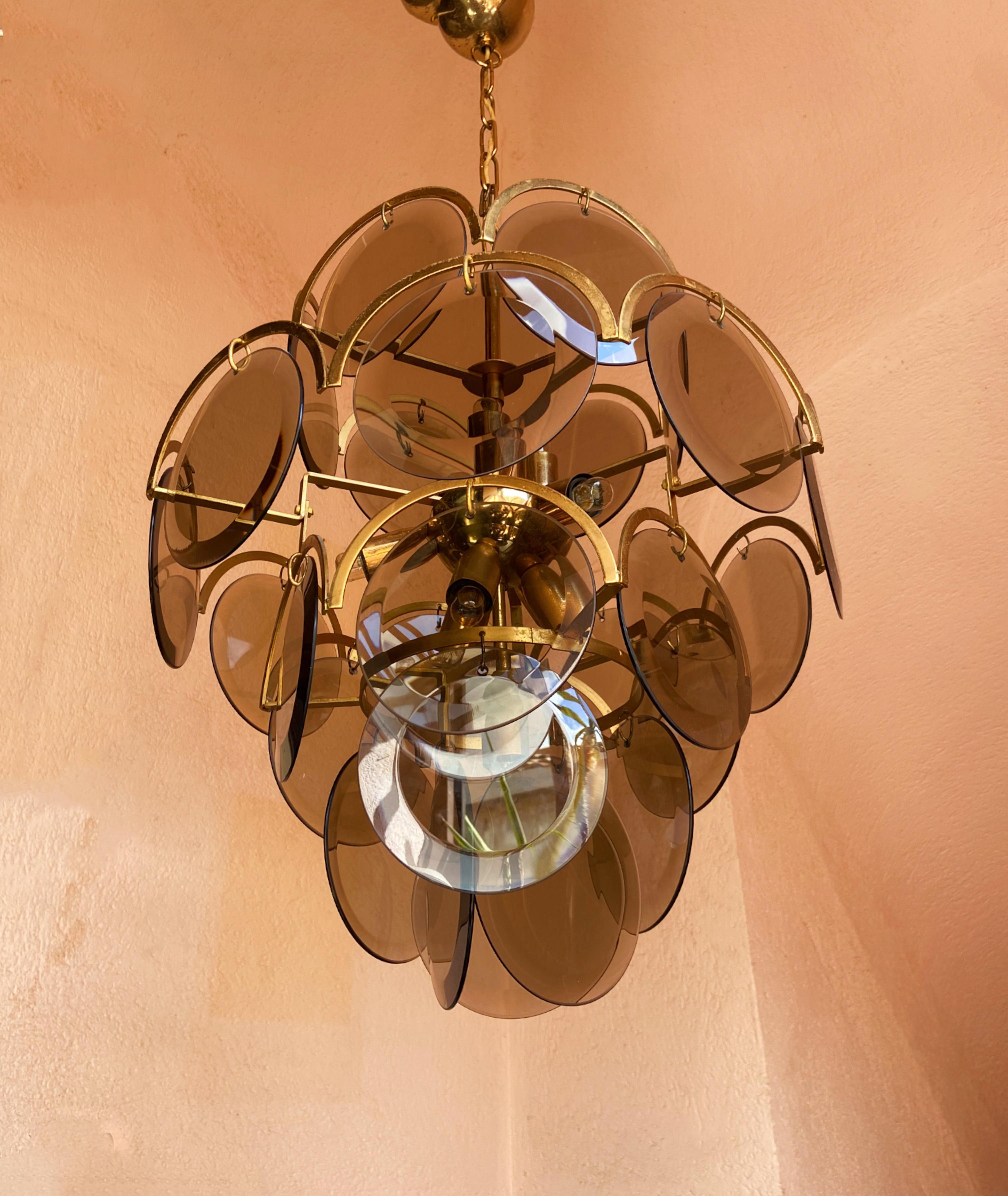 This beautiful luxury chandelier of Murano glass was designed by Gino Vistosi, 1970s. It is made from Murano art glass and is composed of 27 glass discs set on a metal base. The chandelier is in a good vintage condition. 10 light