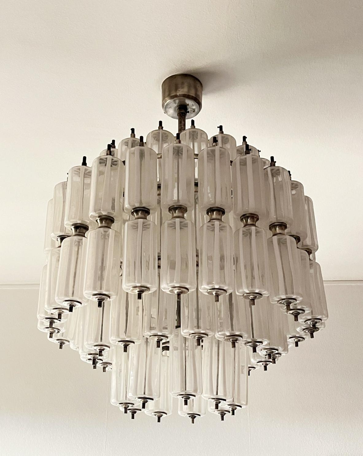 Important Murano glass chandelier composed of 110 transparent cylindrical elements painted on fire using the lattimo technique.

Murano manufacture, Venice, late 1950s.