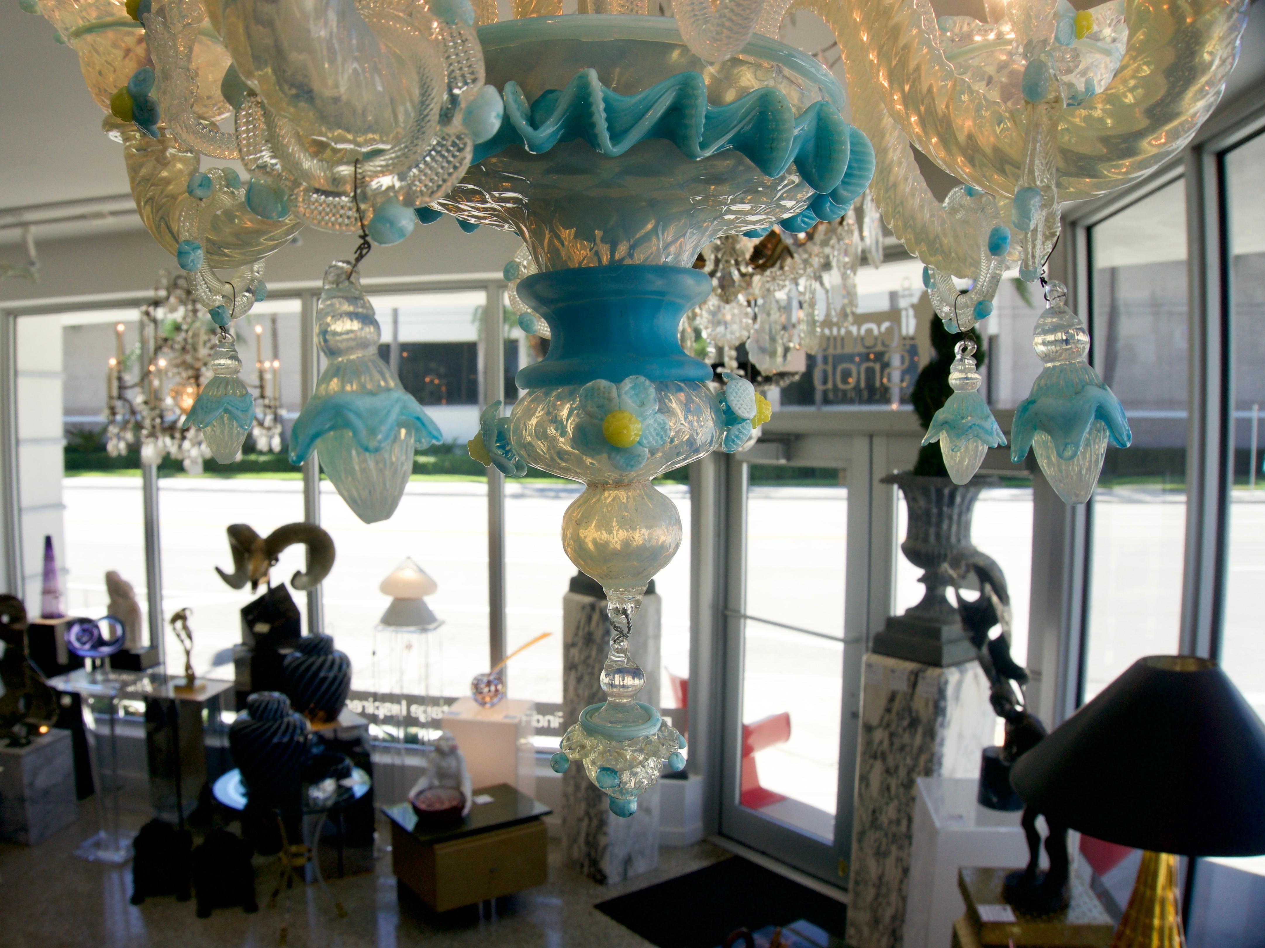Questo lampadario in vetro di Murano Galliano Ferro, elegante e chic, risale alla fine degli anni '60-'70 ed è stato acquistato da una proprietà di Palm Beach. Il corpo principale del lampadario è in vetro opalino traslucido con accenti in blu,