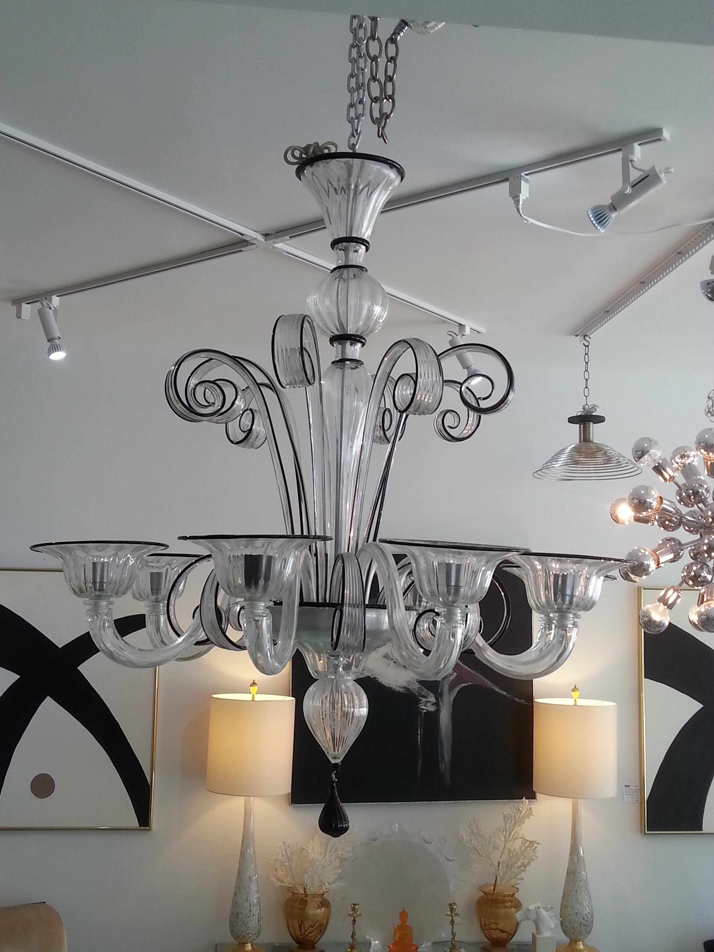 This large scale, stylish and dramatic Murano glass chandelier dates to the 1990s and was acquired from a Palm Beach estate. 

Note: Requires eight candelabra based light bulbs.

Note: Overall height is 62