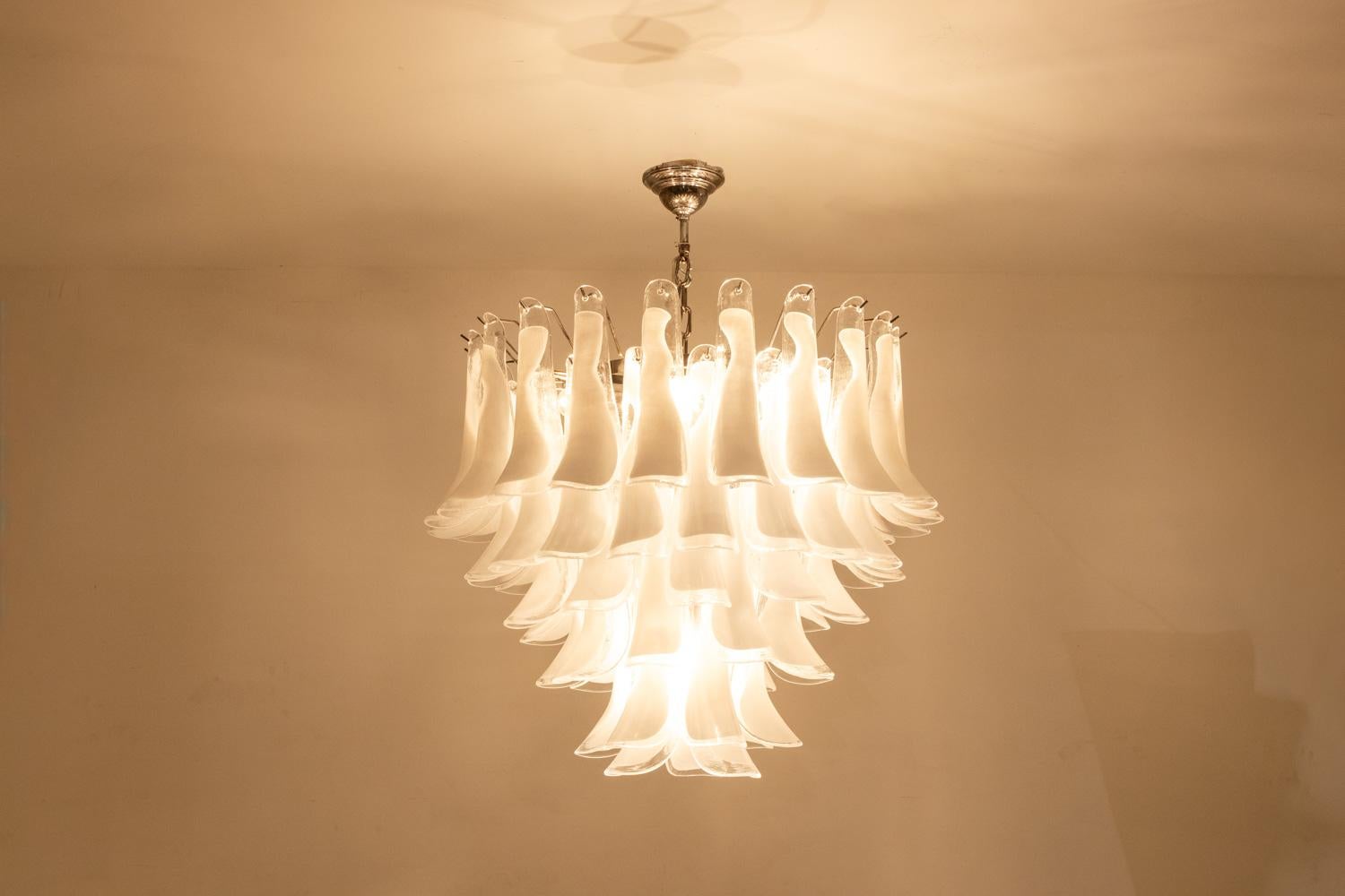 Murano glass chandelier with white and translucent glass petals in 6 rows.

Contemporary Italian design, in the spirit of Mazzega.

Works with 7 E27 bulbs (6 in the upper part of the chandelier and 1 in the lower part).

Dimensions: H 82 x D 66