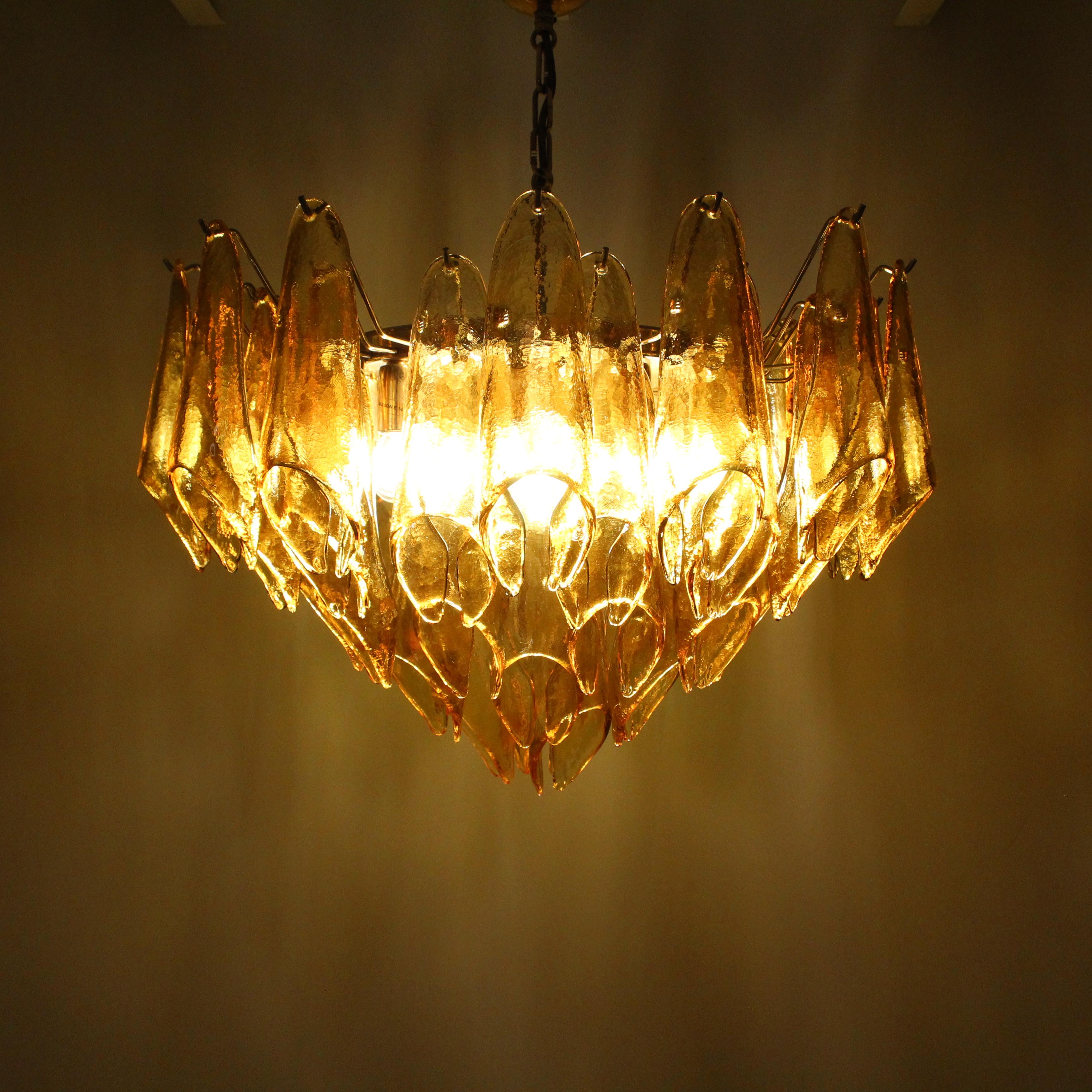 Le magnifique lustre orné d'éléments en verre jaune de Murano est un chef-d'œuvre d'une rare beauté, réalisé par le fabricant réputé La Murrina. Cette création lumineuse incarne le savoir-faire artisanal vénitien qui fait la renommée de la