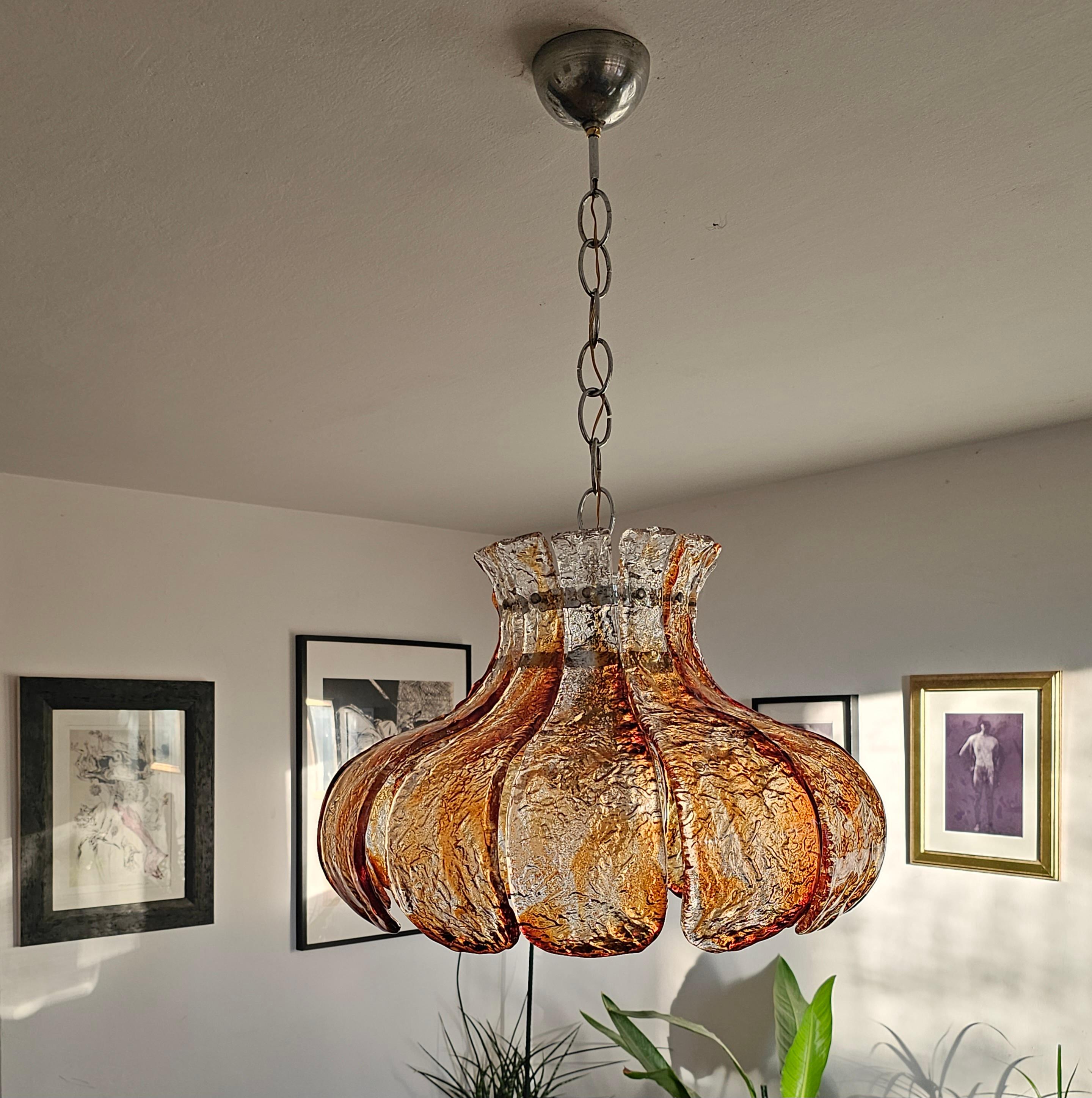 In this listing you will find a Mid Century Modern suspension light done in hand molded and fused dark amber and clear Murano glass petals of Murano glass. This famous model made by the renowned designer Carlo Nason for the MAZZEGA glassworks. Made