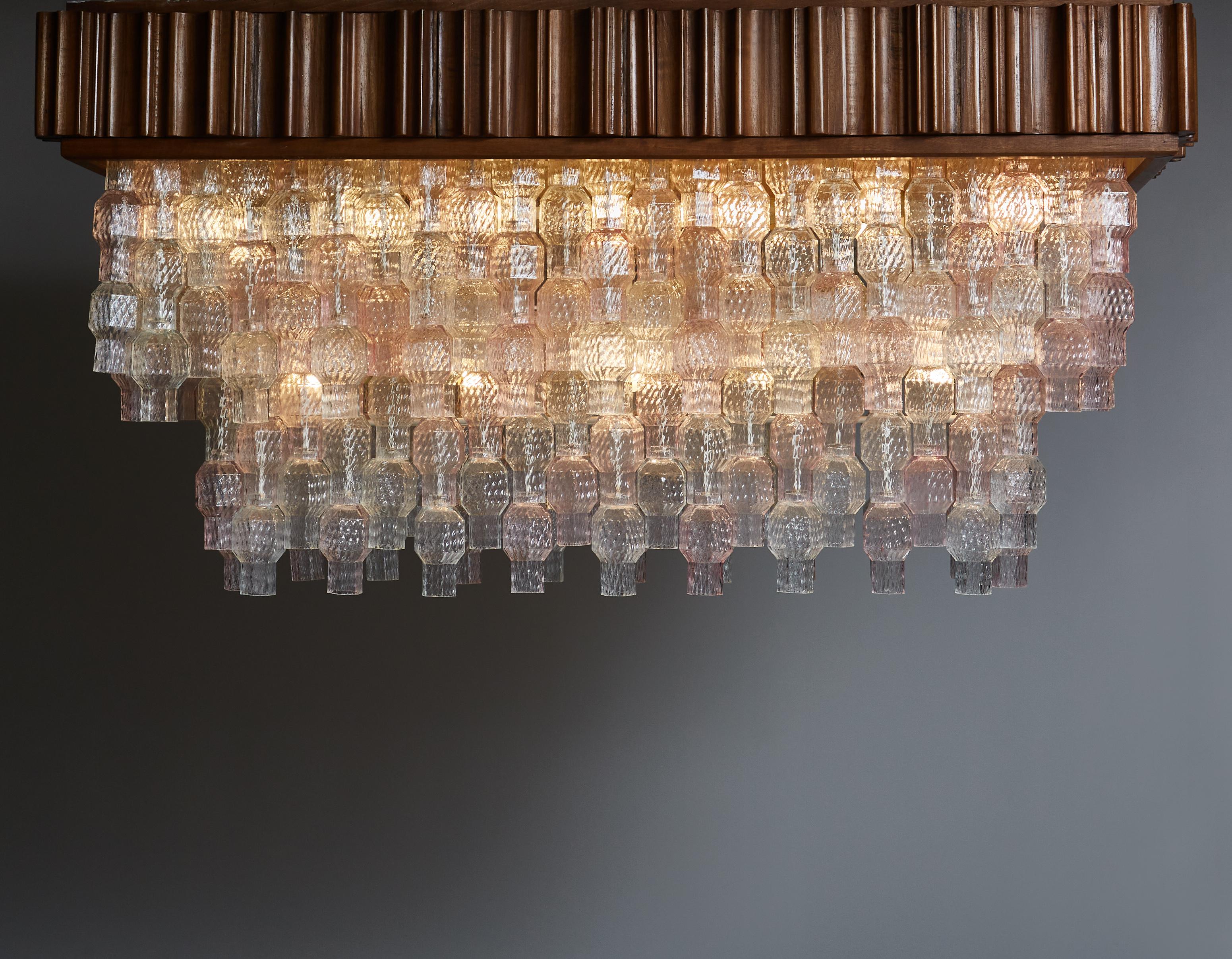 Unusual rectangular chandelier made of stacked clear and pink Murano glass parts, all incased in a removable stained wood case.