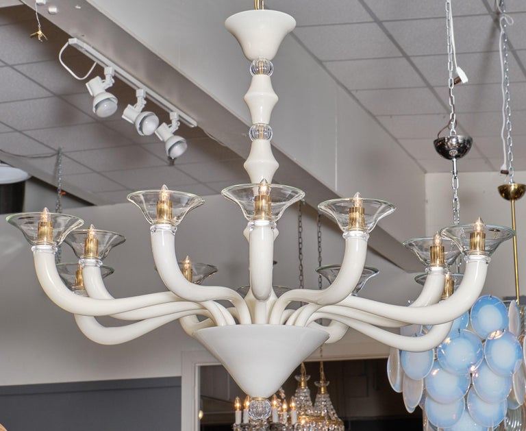 An Italian clear and ivory Murano glass chandelier. This fixture from Venice features 12 branches of ivory “incamisciato” glass with clear glass “boboches.” The rings around the main stem and finial are also clear. This is a flawless fixture that
