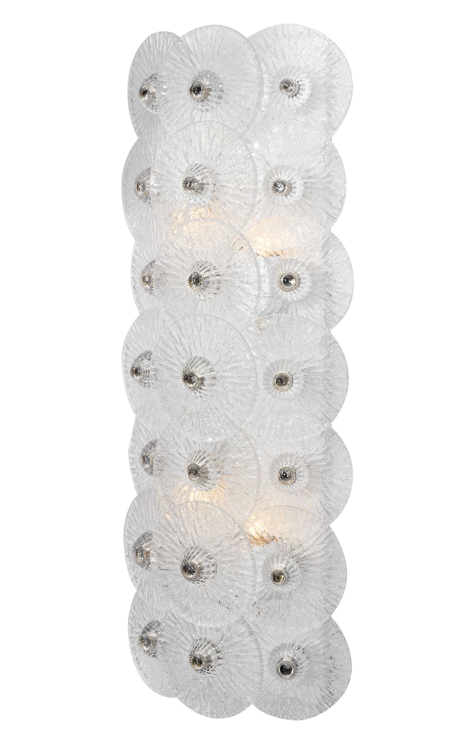 Beautiful Murano glass disc sconces by Carlo Nason. This Italian pair of important fixtures feature 21 clear hand blown glass discs, each textured and arranged vertically on a polished chromed structure. They have been newly wired to fit US