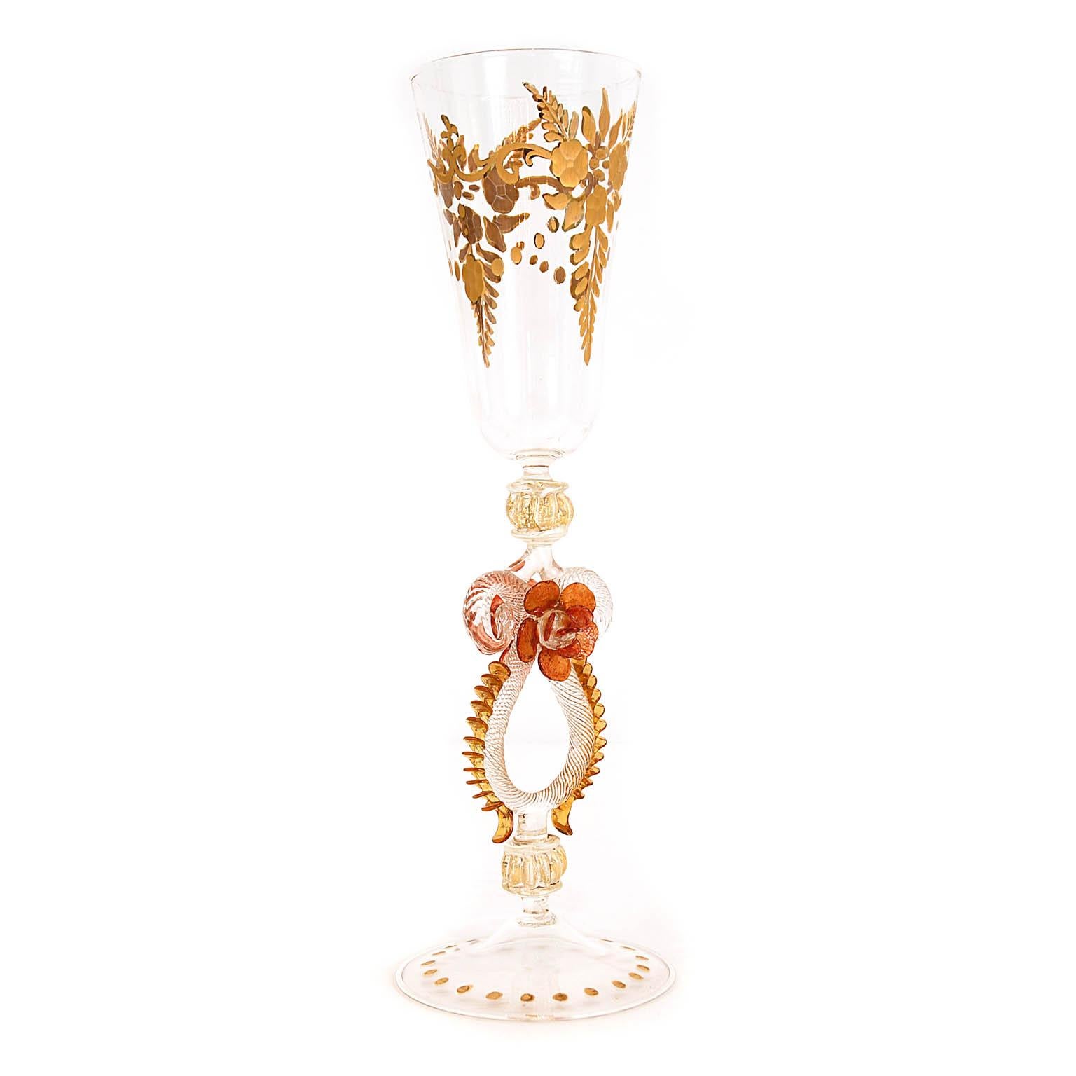 Italian handcrafted chalice in clear, gold, amber and red glass. The stem is cutted and decorated with gold. Due to the cut the gold is glossy and matt.
The base is also decorated in the same way with dots. The stem is adorned with different Morise