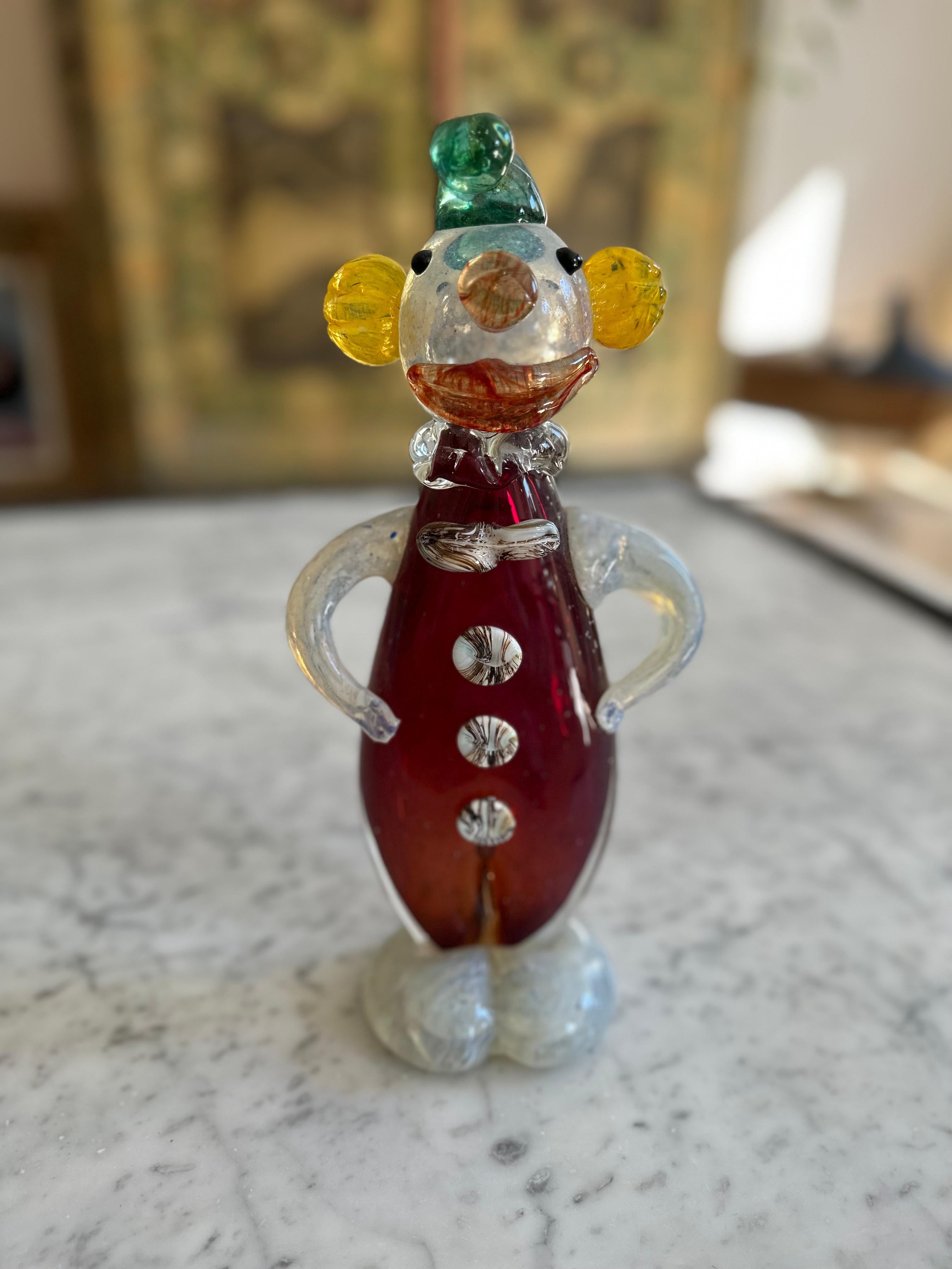 Introducing a delightful piece of artistry, this Murano glass clown figurine is a testament to the exquisite craftsmanship that the island of Murano, Italy, is renowned for. Created in the latter half of the 20th century, it embodies the spirit of