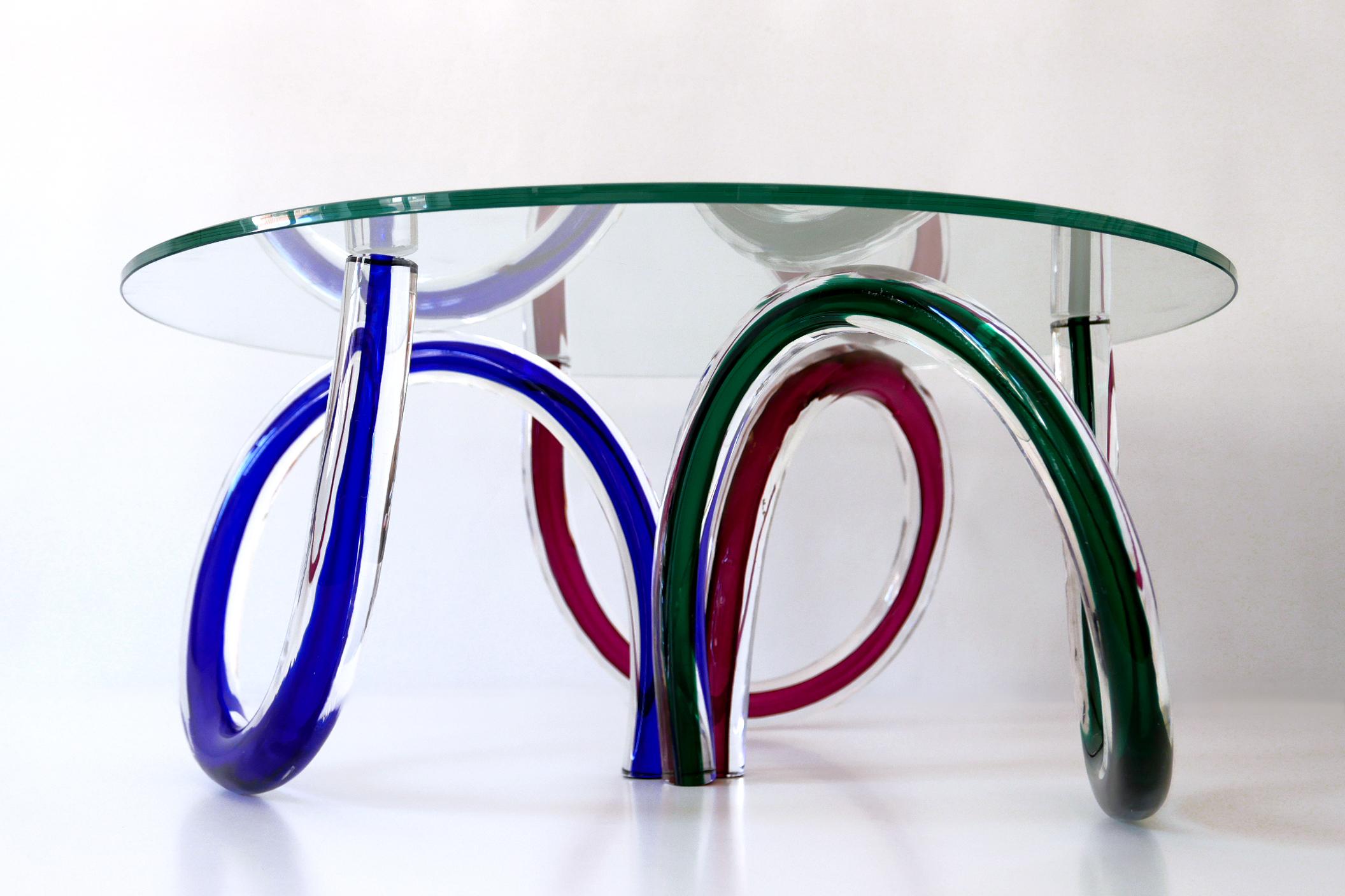 Gorgeous coffee table with three green, red and blue colored base elements. Designed by Maurice Barilone for Roche Bobois, Italy, 1980s.

Executed in three Murano Art Glass base elements and clear glass top.

Dimensions: 
Dm 28.74 in. (73 cm)
H 12.6