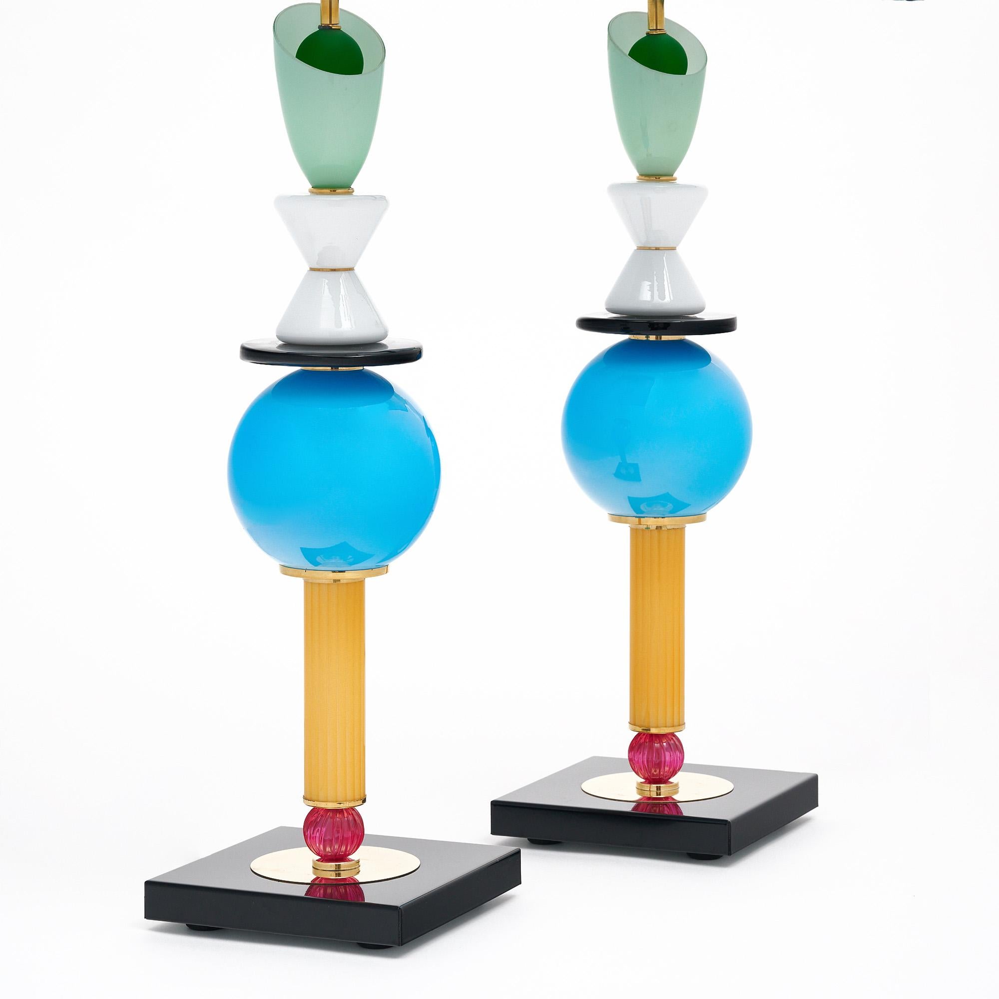 Paire de lampes provenant de l'île de Murano à Venise, Italie. Les lampes présentent un ensemble d'éléments géométriques colorés en verre de Murano reposant sur une base carrée en métal noir. Elles ont été nouvellement câblées pour répondre aux