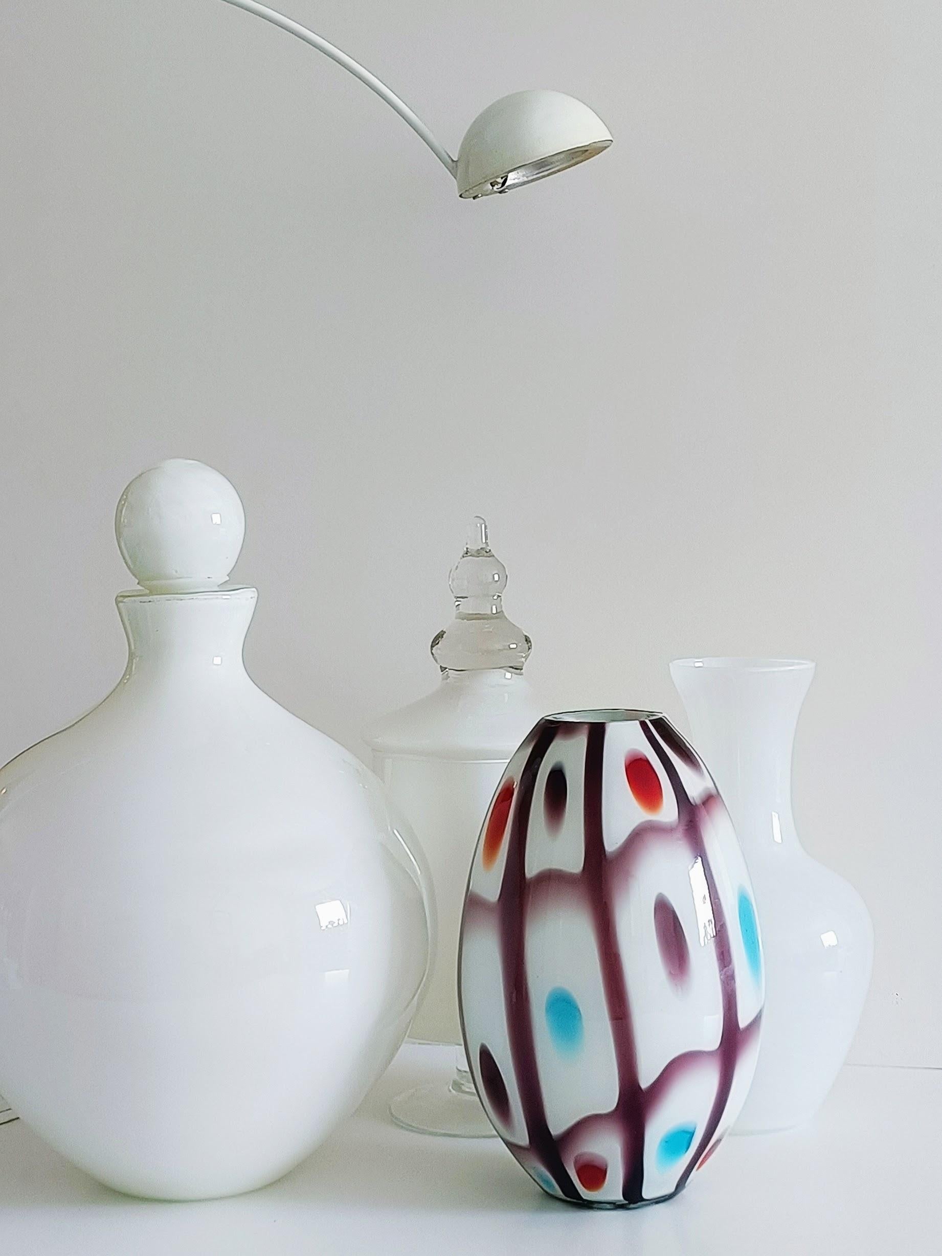 Diese atemberaubende Vase aus Murano-Glas in eiförmiger Form im Stil von Anzolo Fuga besticht durch ihr hellviolettes Karomuster. Elliptische Flecken in Orange, Türkis und hellem Lila verleihen dem Design einen lebhaften Kontrast. Sie wird mit einem