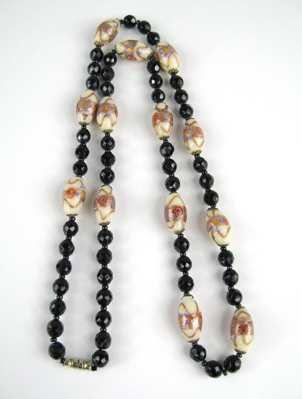 A STUNNING strand of vintage Murano Glass Beads. 
These Have copper, blue and cream in the oval beads and faceted black beads They run 3 faceted one oval with are capped in a gold tone Barrel clasp, Beads measures 11.65mm x 21.5mm, black beads are