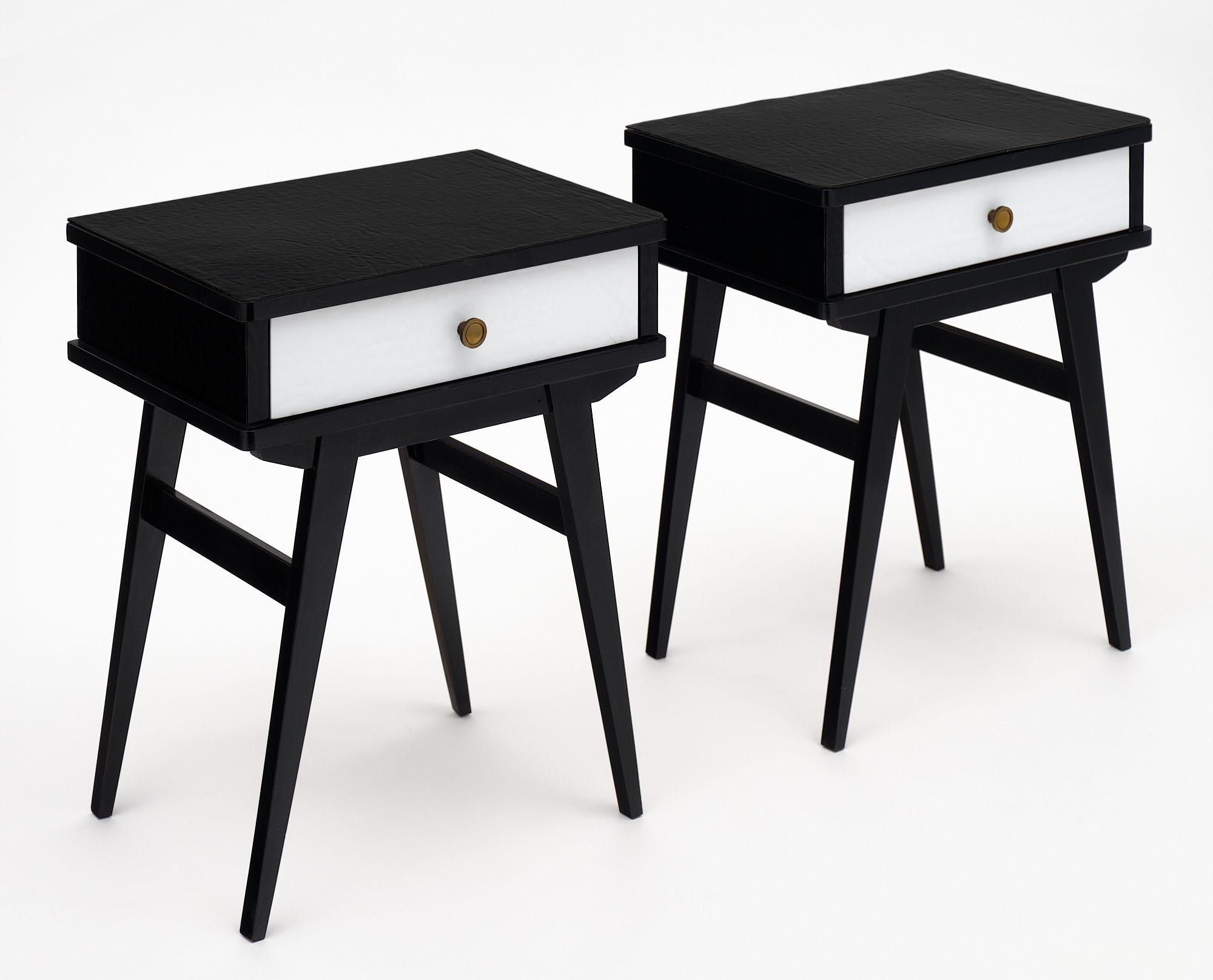 Paire de tables d'appoint d'Italie plaquées en verre de Murano texturé noir et blanc. Chaque meuble comporte un tiroir avec un bouton en bronze et est soutenu par des pieds ébénisés.